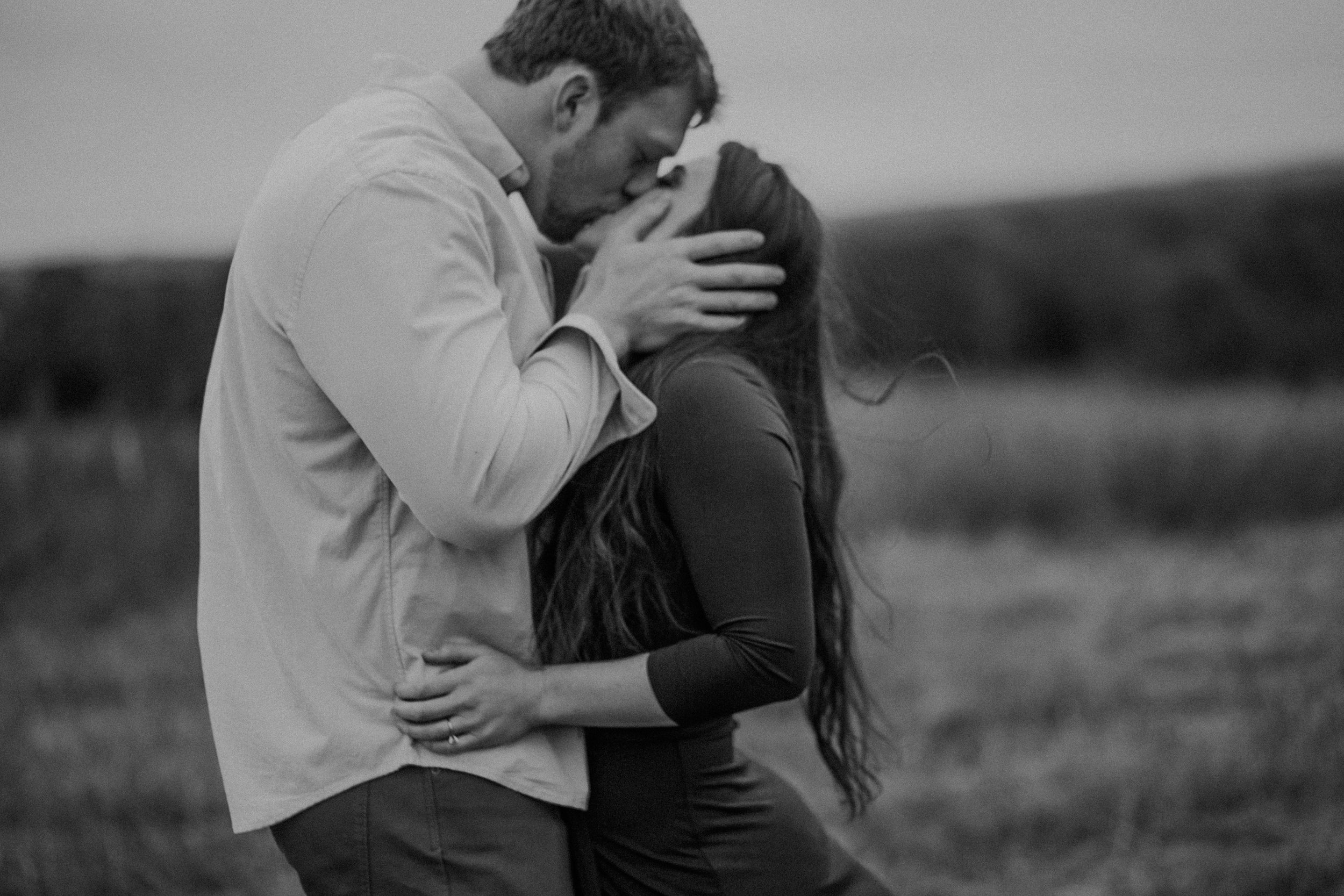  A couple kisses romantically while Andrea Wagner Photography takes a photo in black and white 