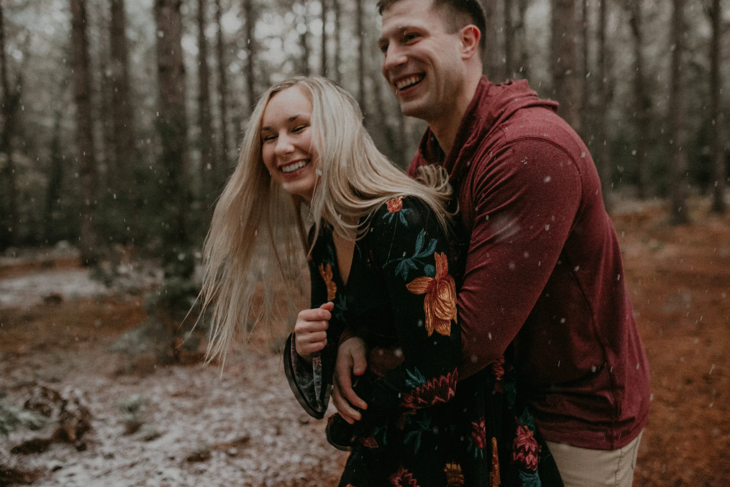 a couple plays and laughs during their engagement session with Andrea Wagner