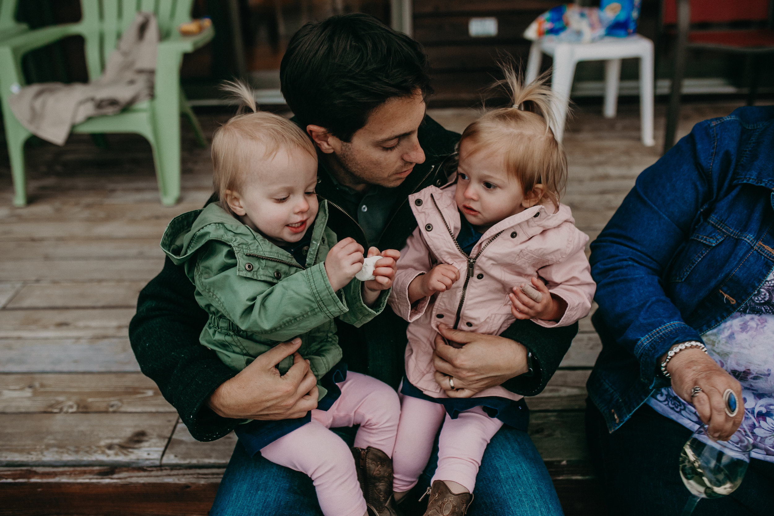 Andrea Wagner Photographer captures sweet moments between twin toddlers and their dad during a lifestyle family photo shoot on Madeline Island
