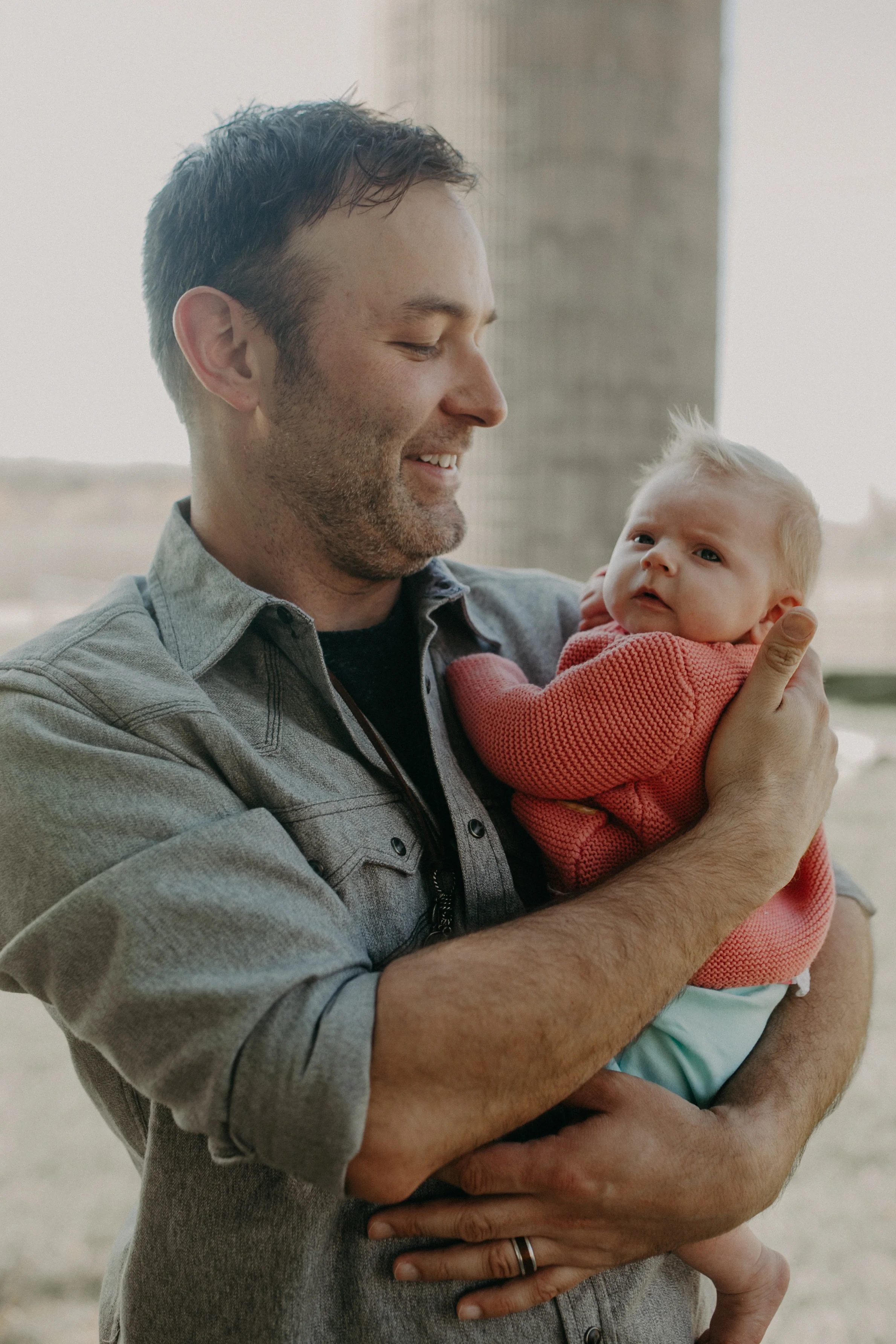 gay dad who lives on a farm in River Falls WI holds his newborn adopted daughter