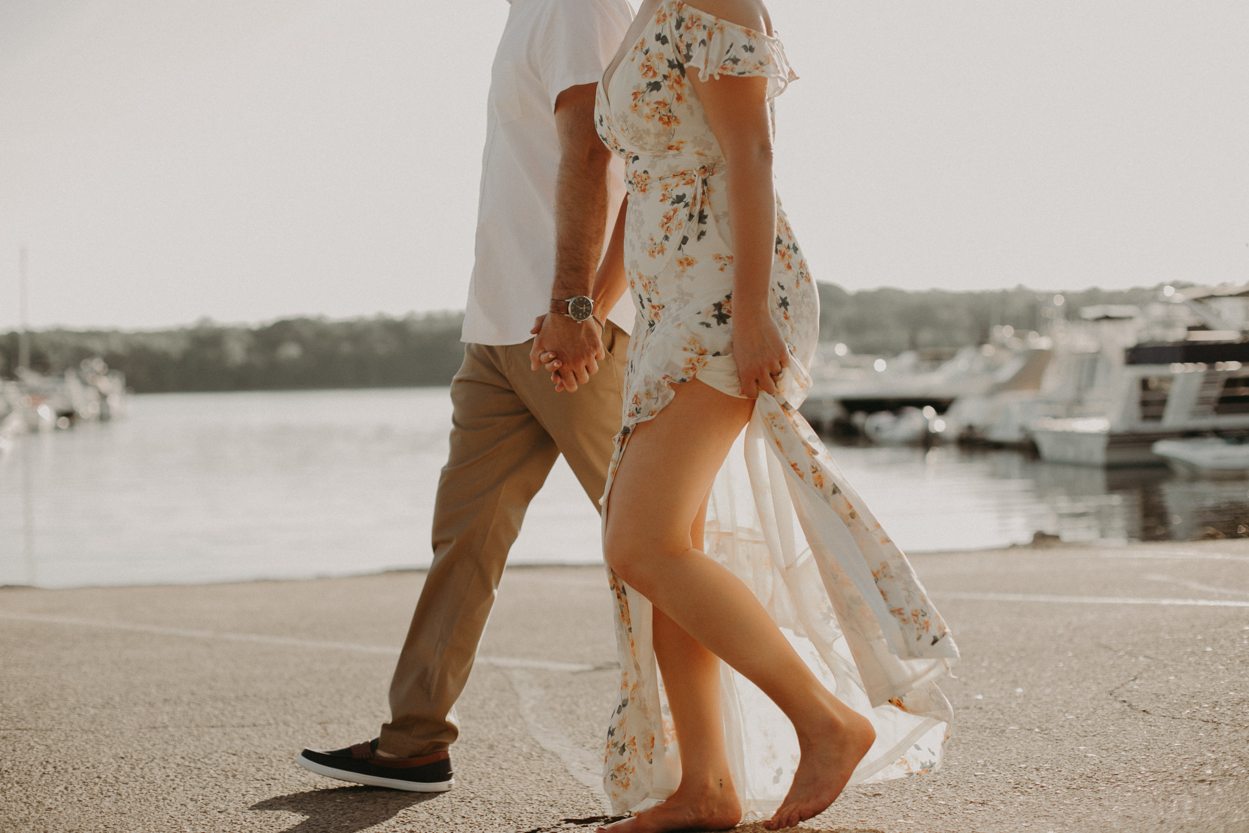 a couple strolls holding hands at the St Croix Marina during an engagement session with Andrea Wagner Photography