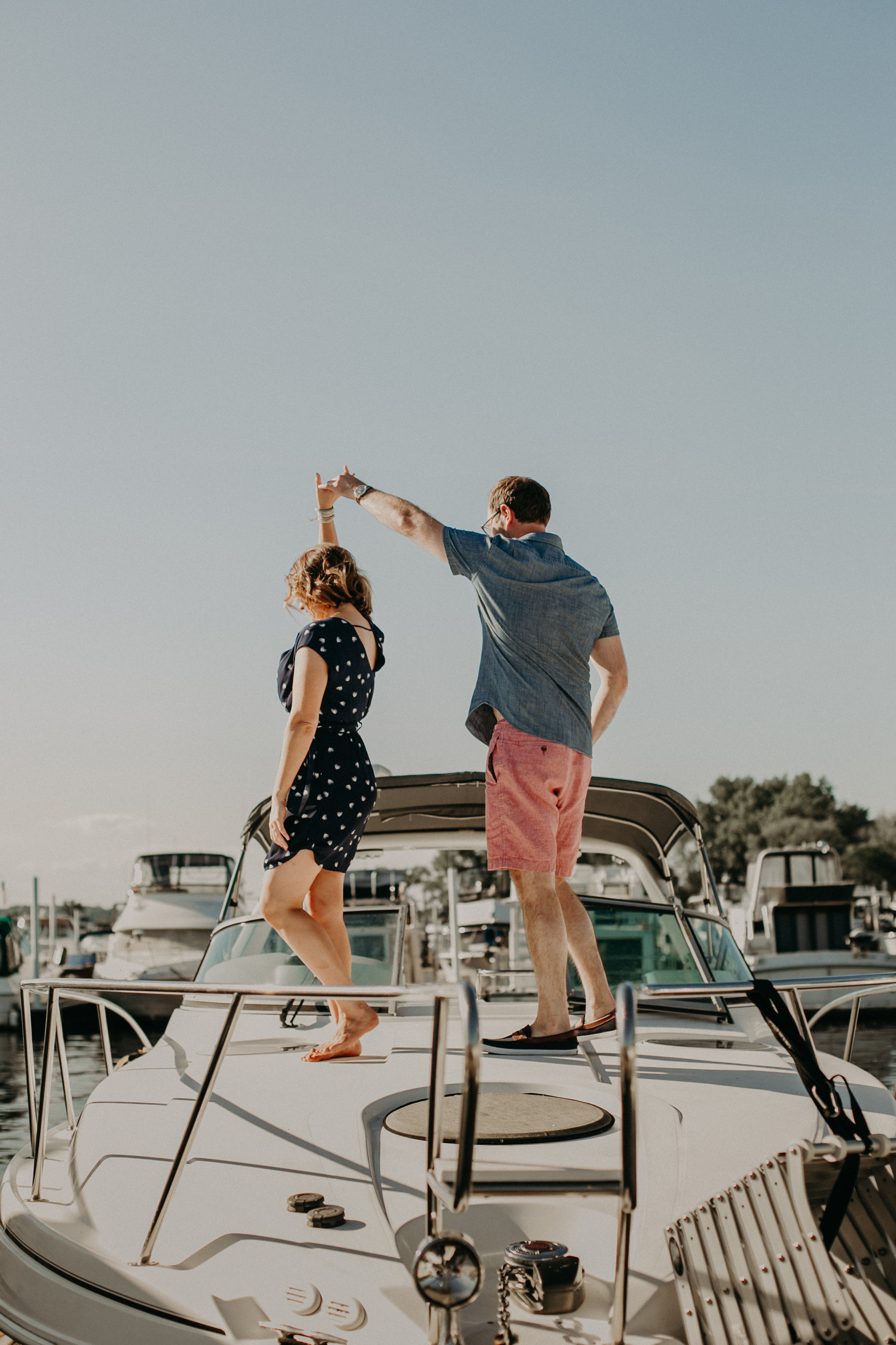 a couple dances during their engagement session on top of their boat located in Hudson WI in the St Croix Marina