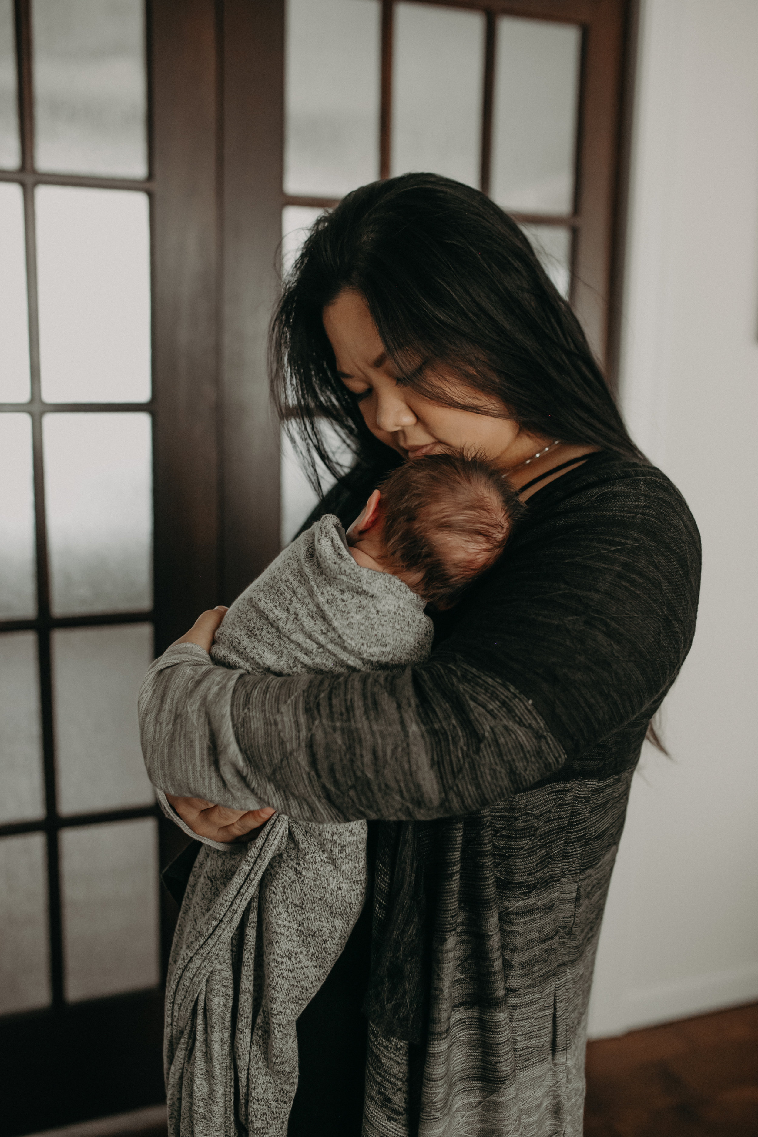 mom snuggles baby during newborn lifestyle session