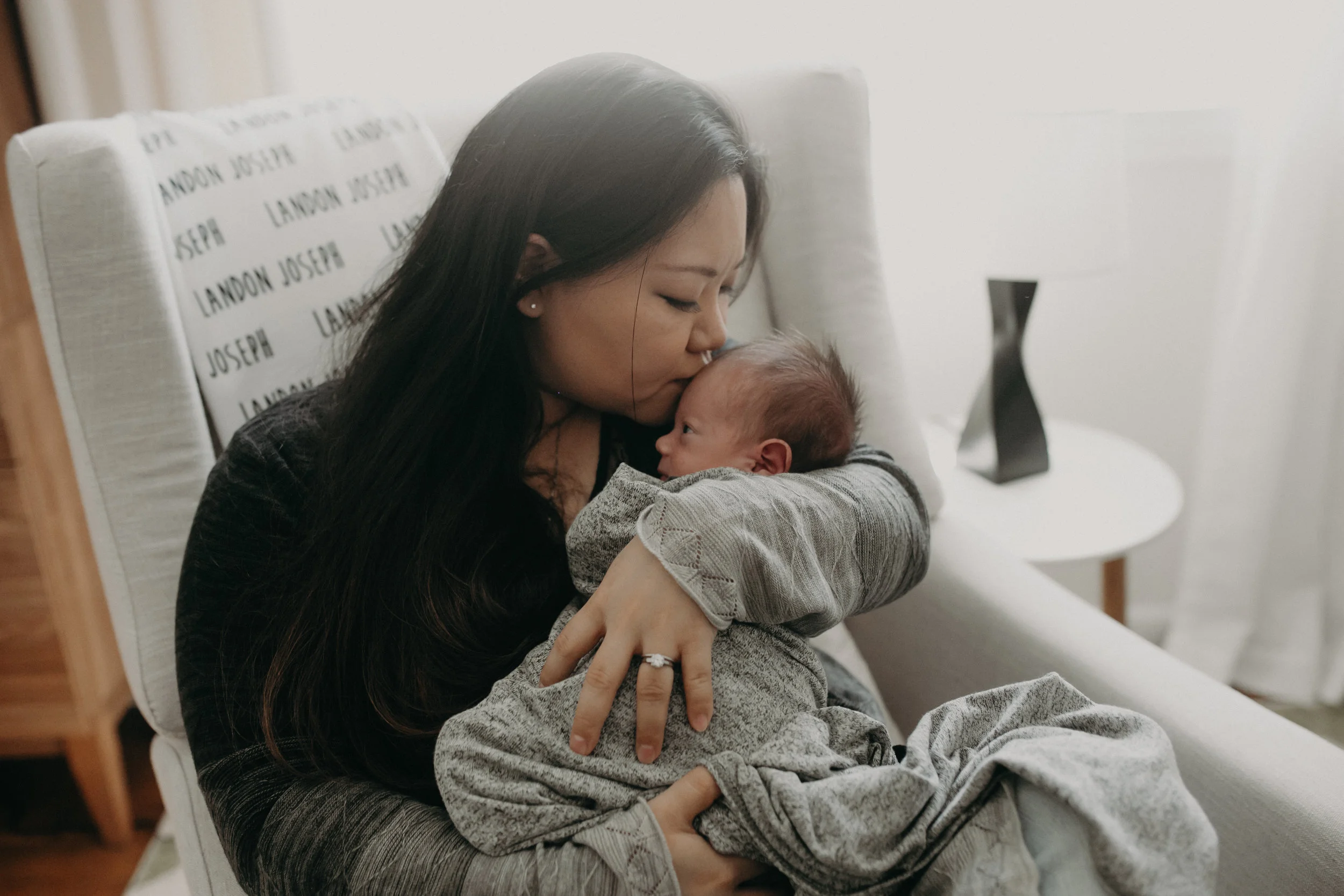 mom kisses her newborn baby boy during this photo session in Wausau WI