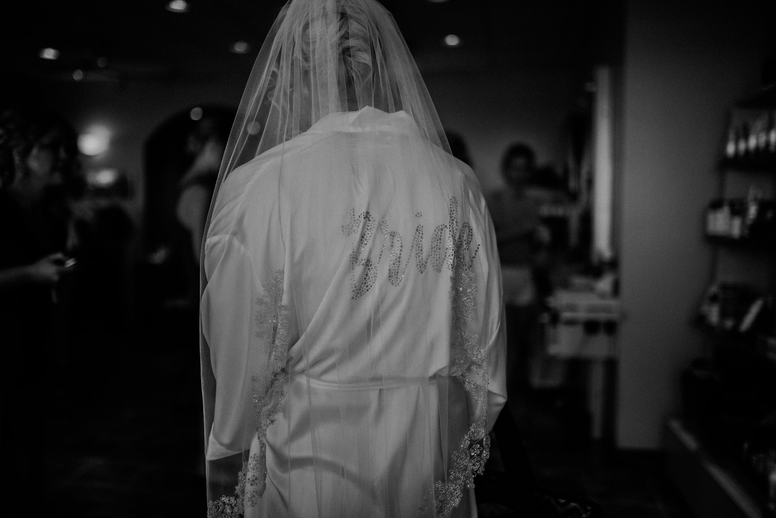  moody black and white photo of a bride in Marshfield WI getting ready at Blues Hair Studio 