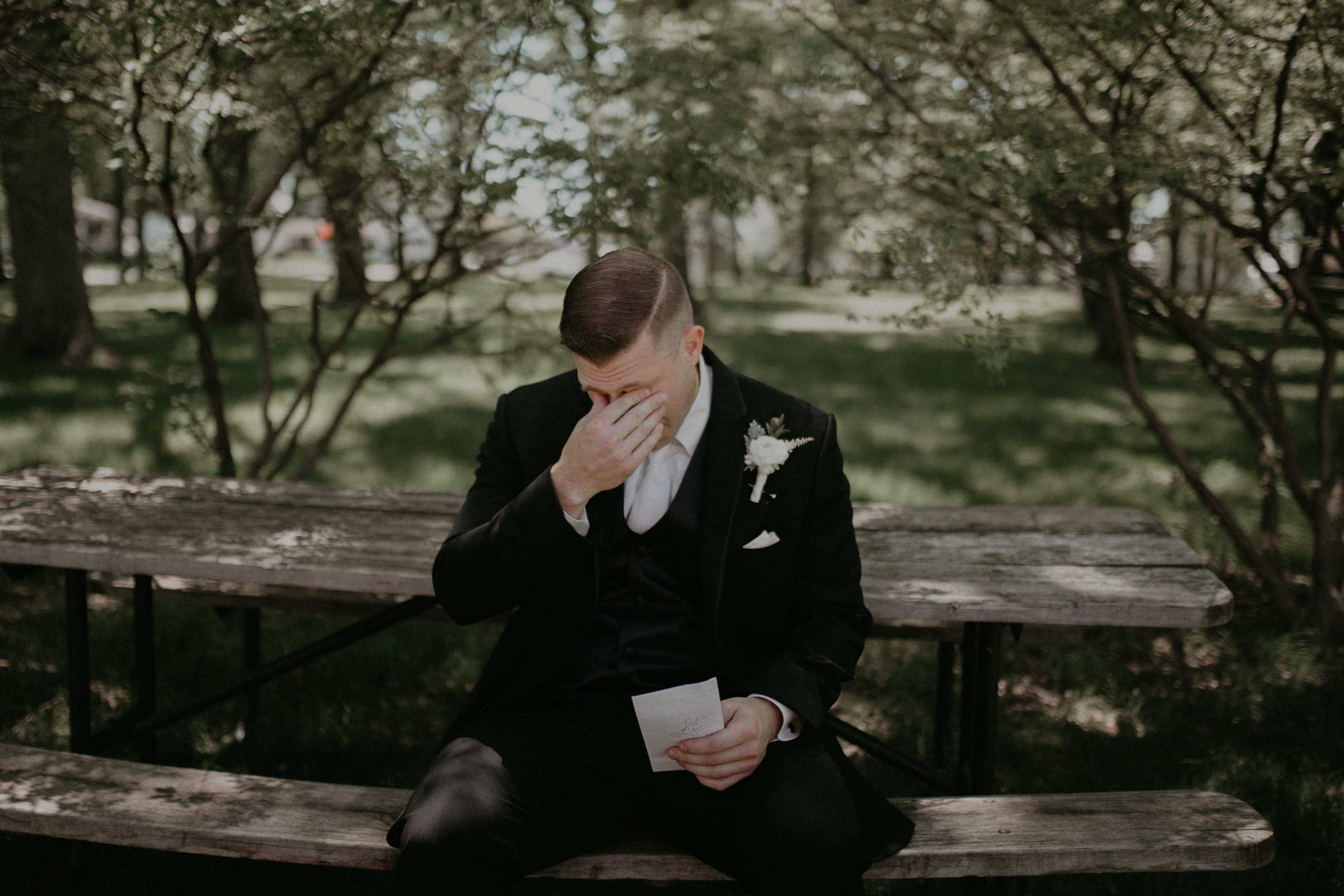 Marshfield WI groom cries while reading a love letter from his bride and is photographed by wedding photographer Andrea Wagner