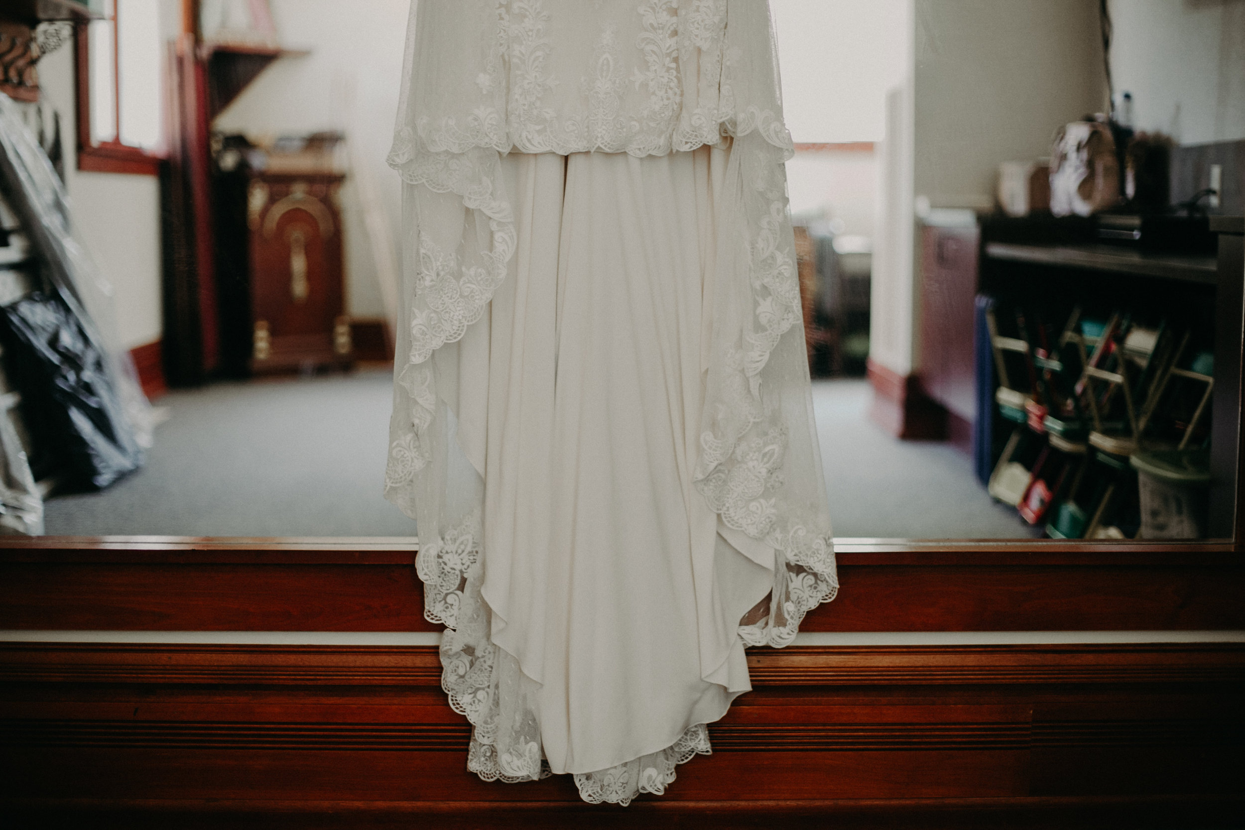 Justin Alexander lace wedding dress hanging in St Johns Catholic Church in Marshfield WI wedding by Andrea Wagner