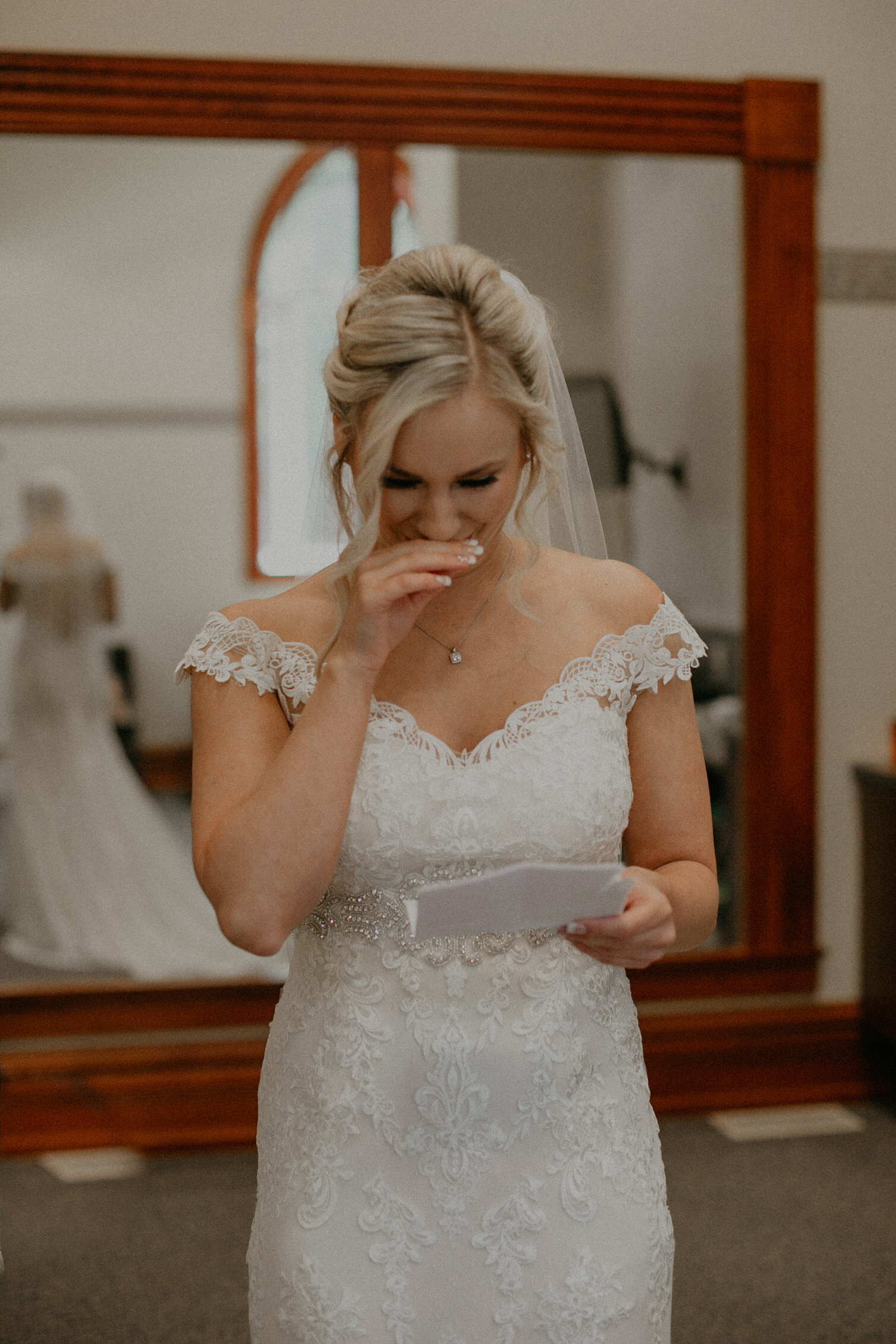 Bride cries while reading a love letter from her groom while Andrea Wagner captures real and authentic moments