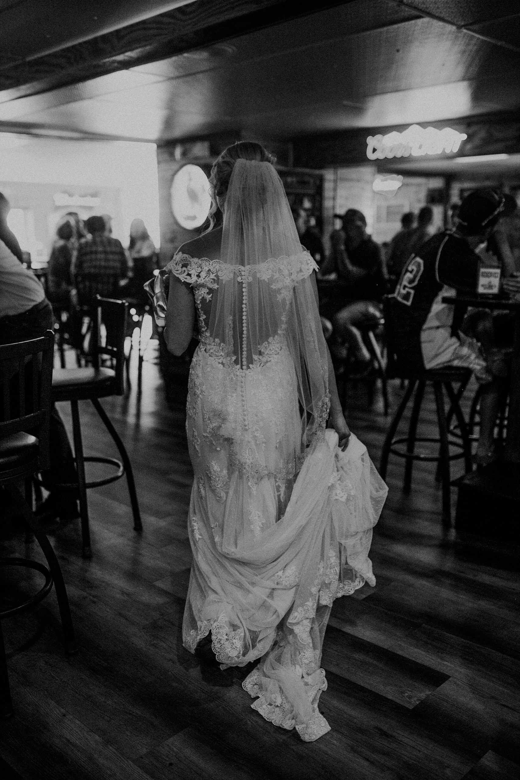  bride walks through a Marshfield bar Nutz Deep II while photographed by Andrea Wagner 