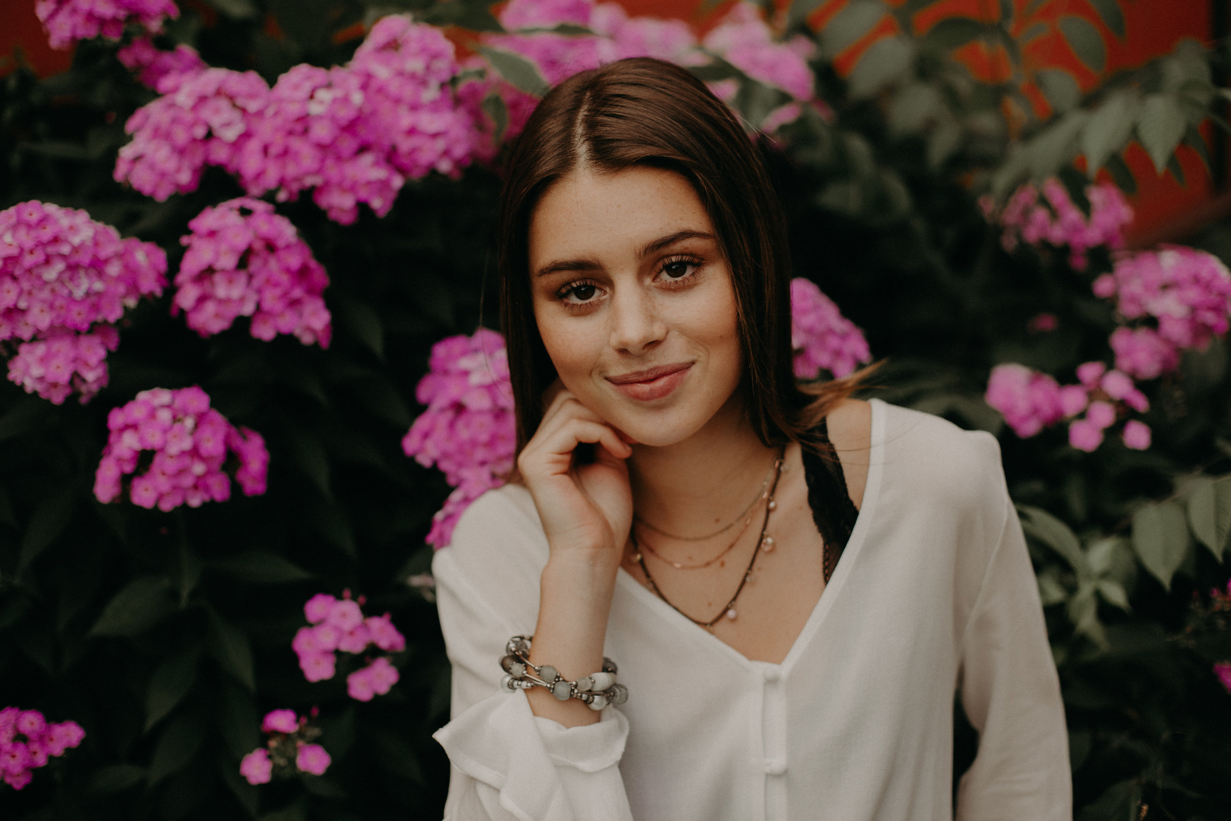  Andrea Wagner Photography captures colorful pink flowers in the background of a high school senior’s photos in Stillwater MN 