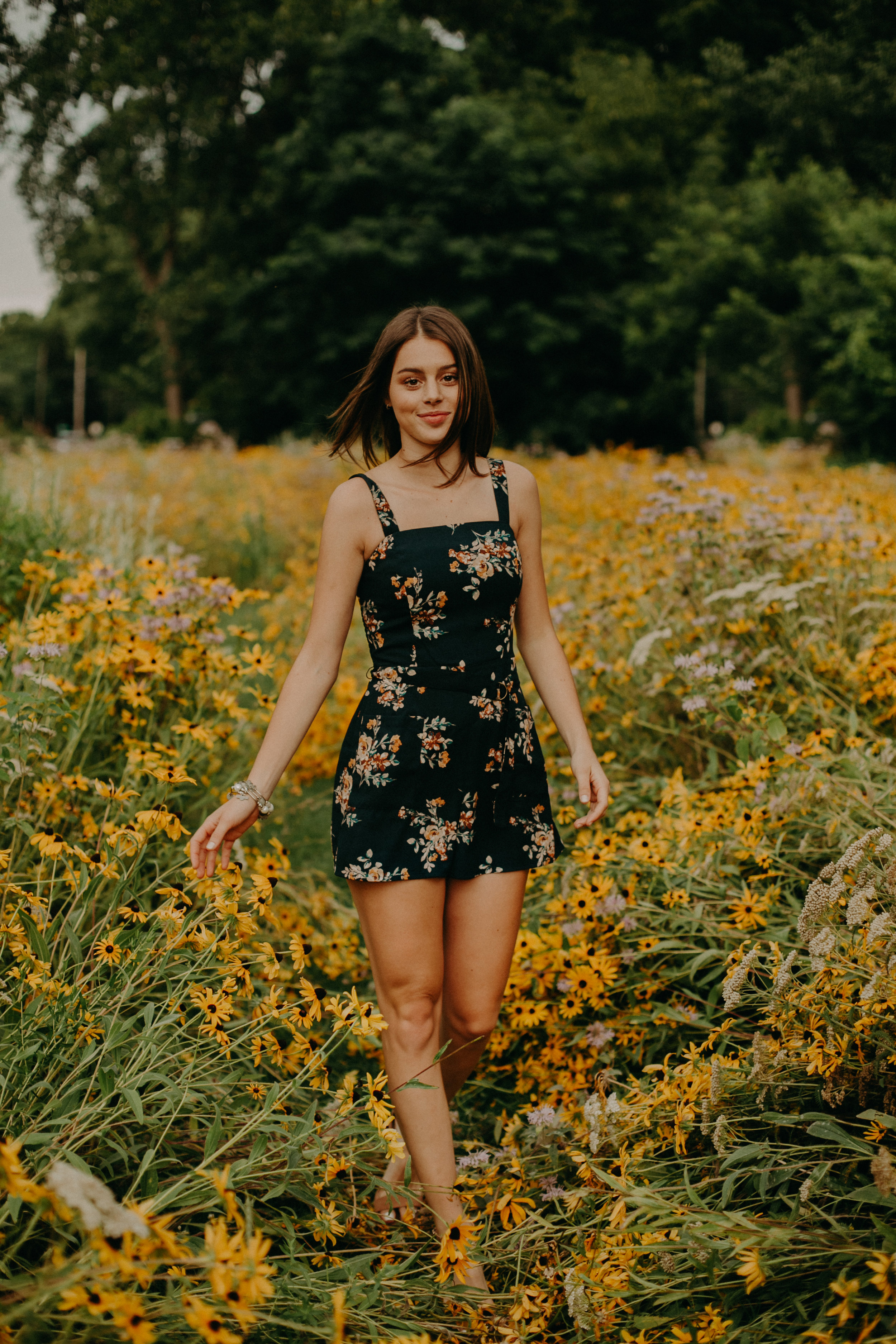  Hudson High School senior poses in daisy field for senior portraits with Andrea Wagner 