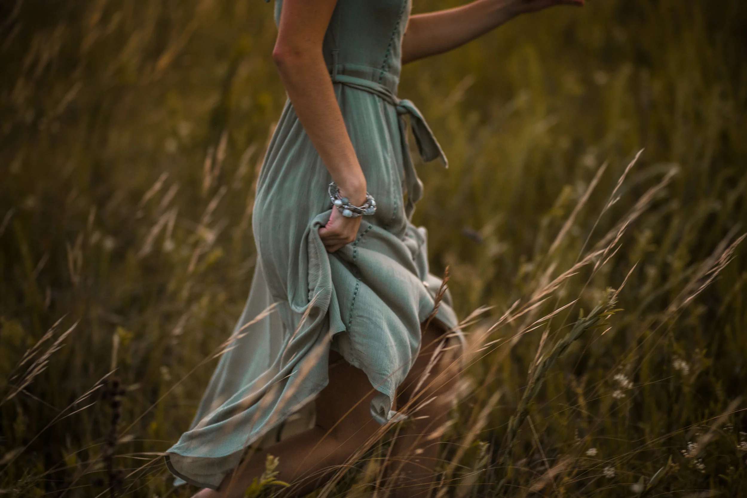 Hudson High School senior runs through a meadow during her photo session with Andrea Wagner in Stillwater MN