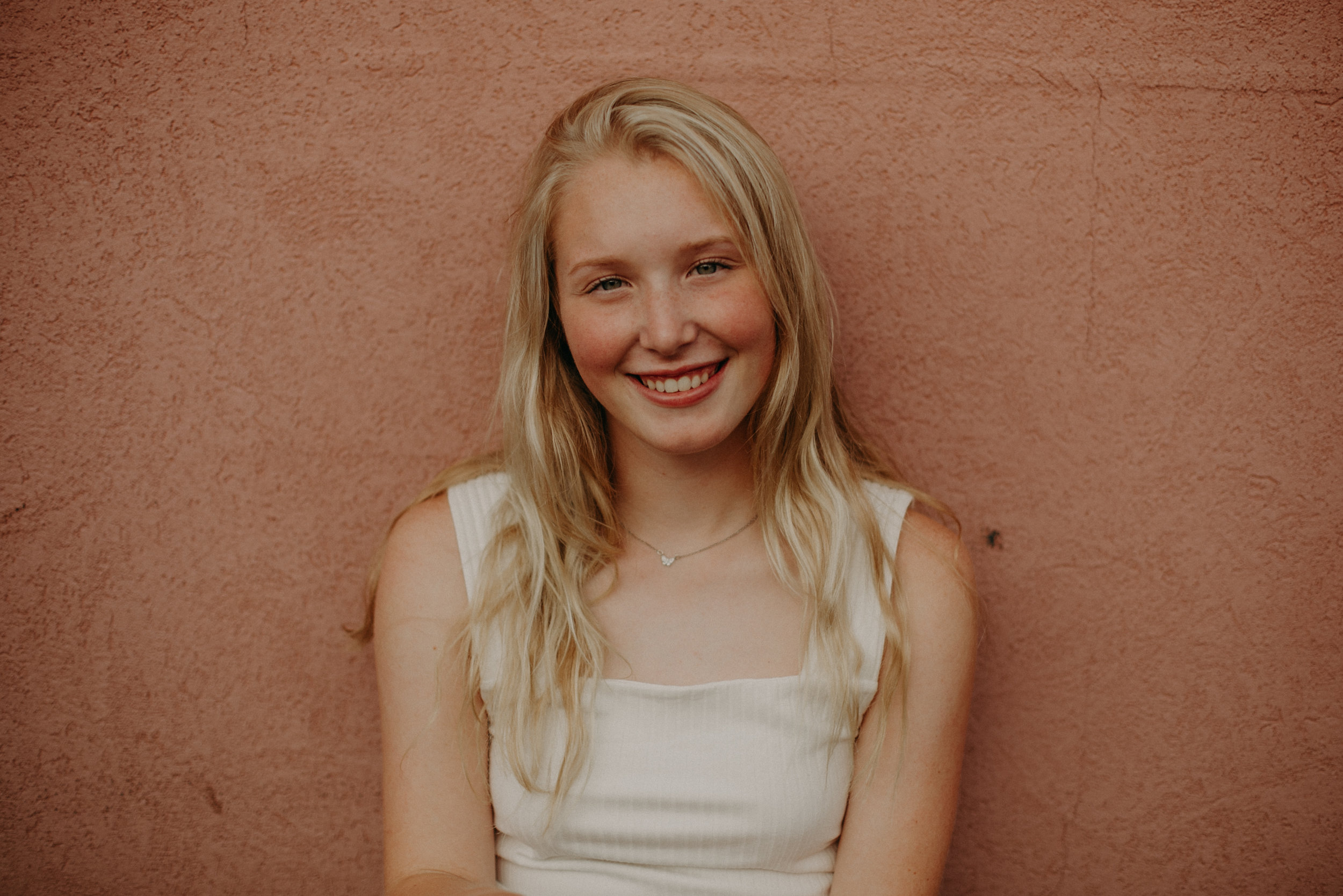pink wall in Hudson WI used for senior portraits by Andrea Wagner Photography