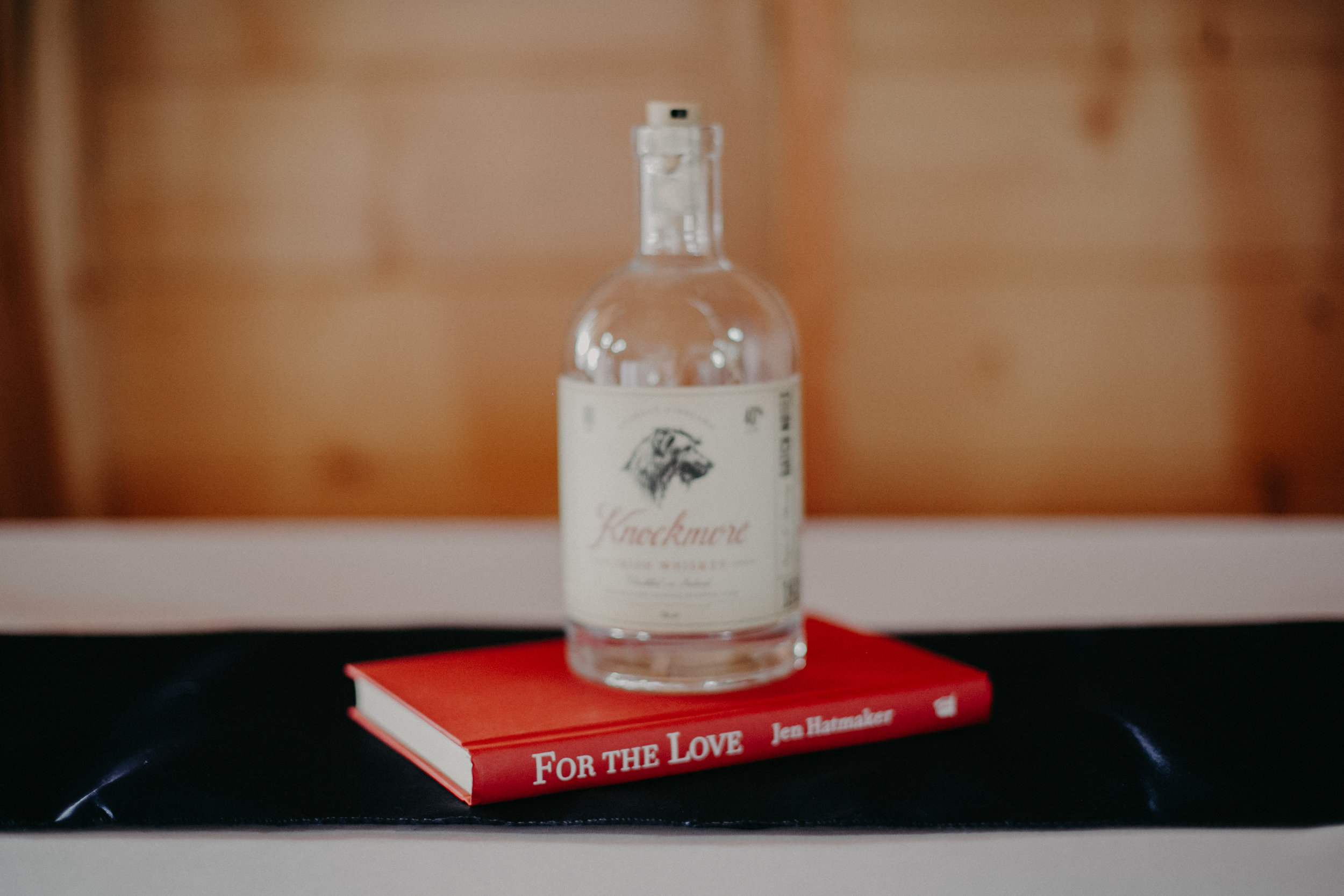 whisky bottle and Jen Hatmaker book make great and interesting wedding decor at wedding in Ellsworth WI at Jean Acres