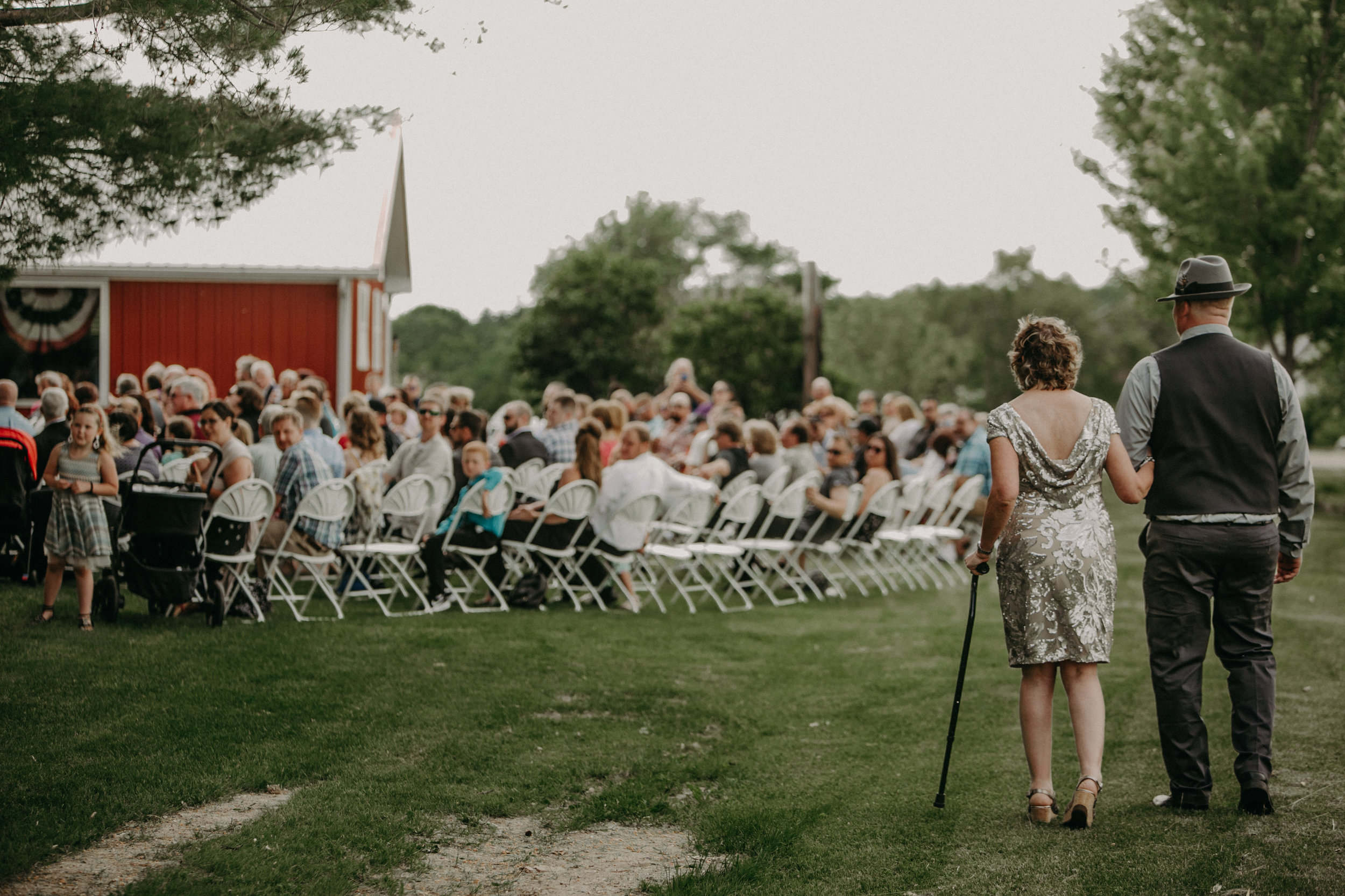  Ellsworth WI wedding photographer Andrea Wagner captures a moment where the groom walks his mother down the aisle at Jean Acres Barn 