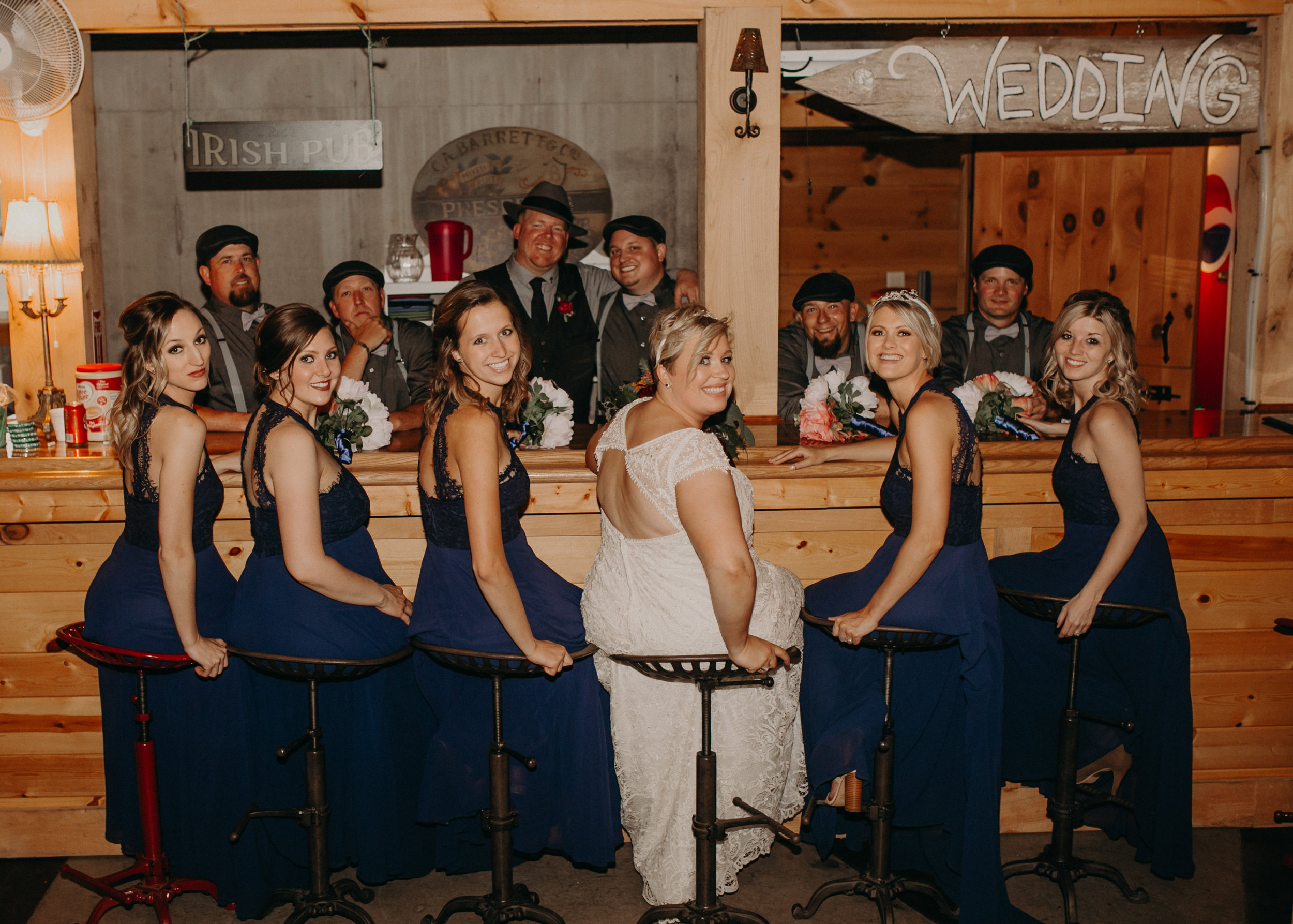  bridal party poses for a photo at the bar at Jean Acres in Ellsworth WI captured by Andrea Wagner Photography 