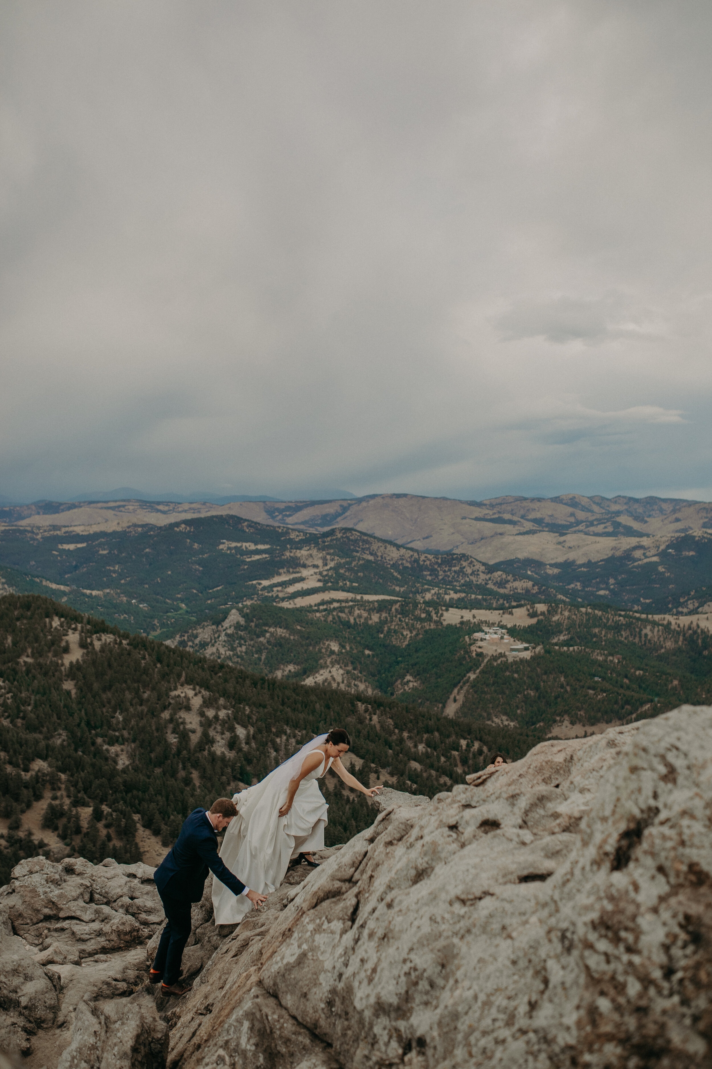  a bride and groom climb up a mountain during their elopement at Lost Gulch 