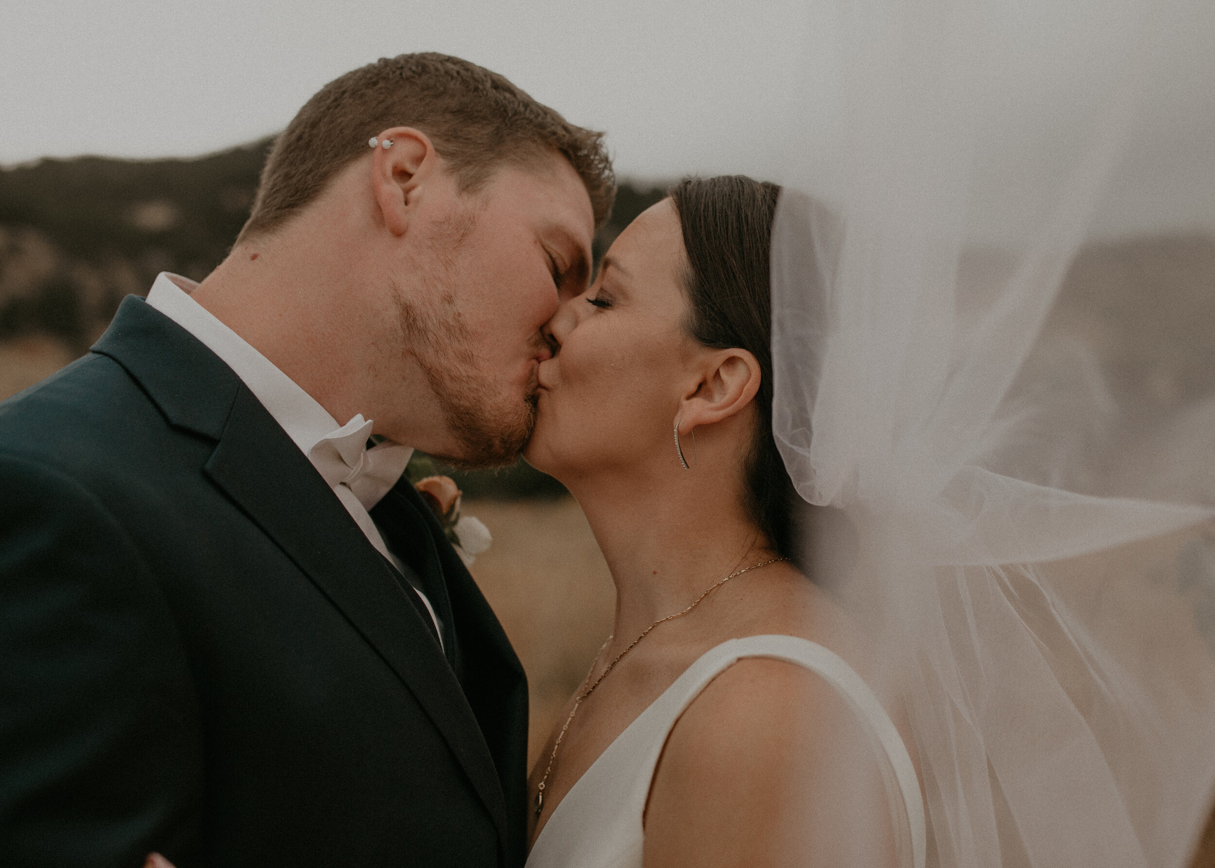  a bride and groom kiss underneath a veil at Chautauqua Park 
