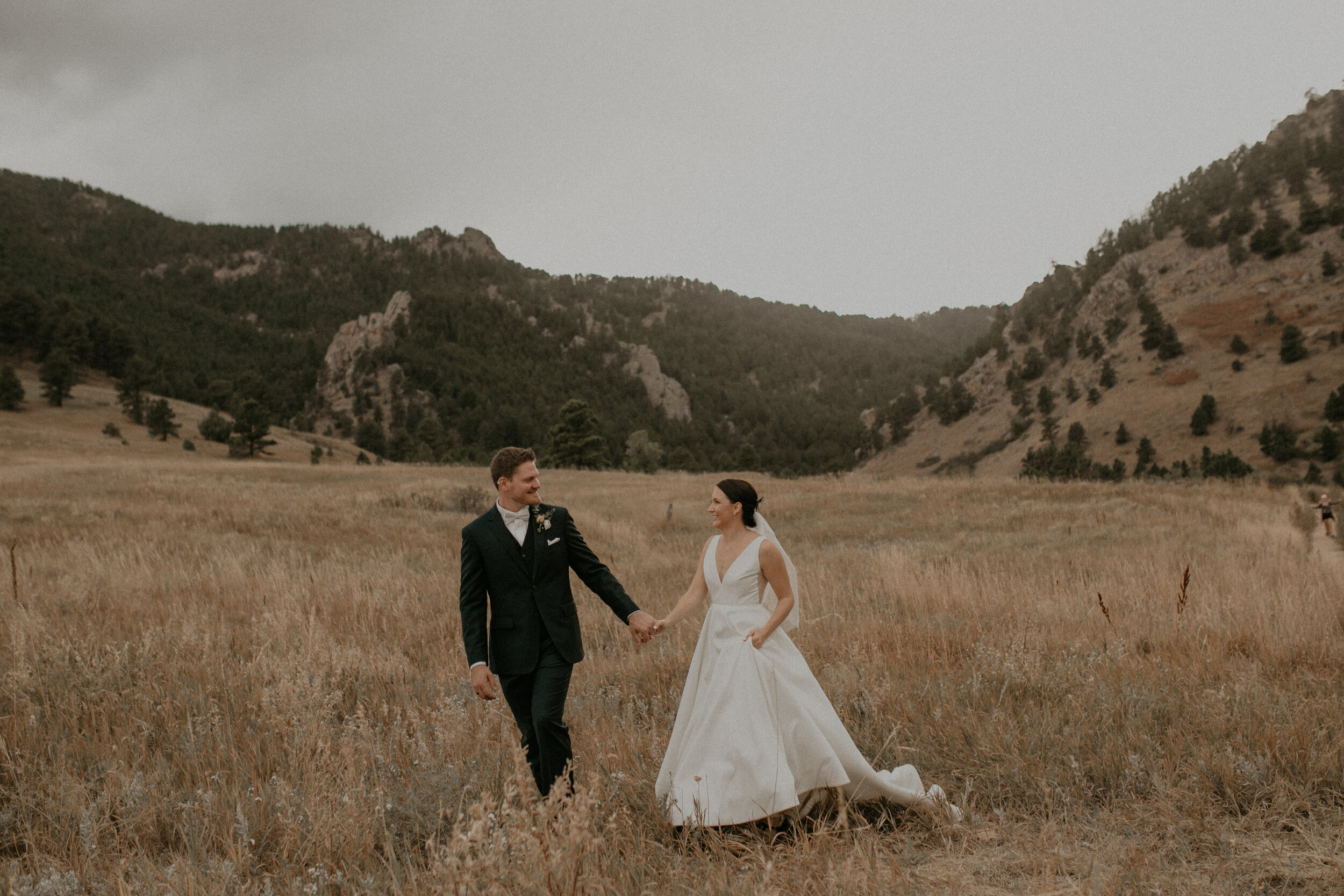  a bride and groom run around Chautauqua Park during their wedding in Colorado WI 