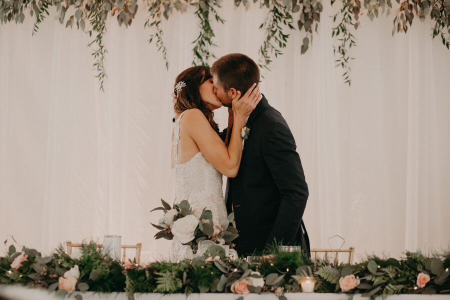 Waupaca wedding kiss between bride and groom during dinner at Par 4 Resort