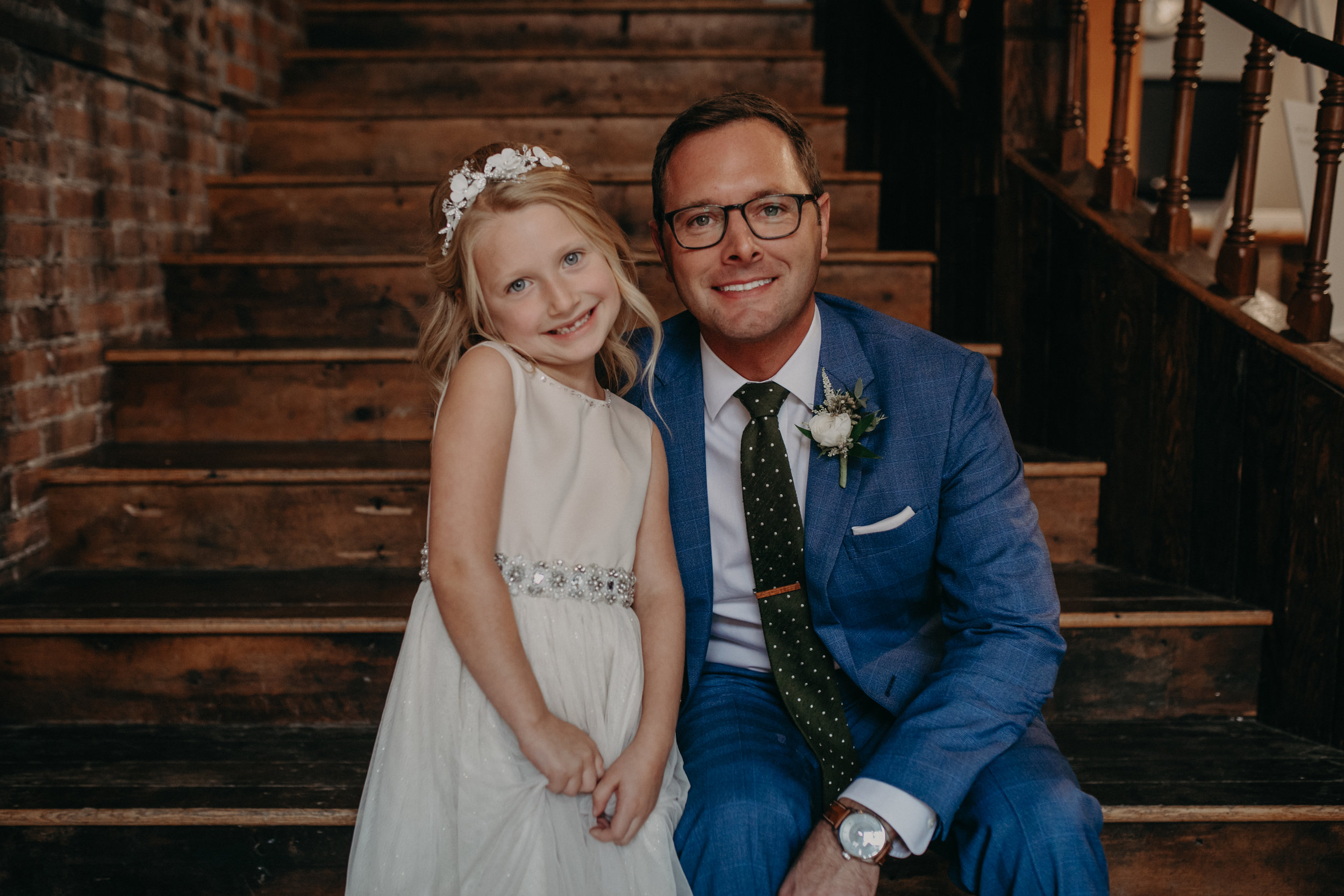 a groom wearing Brooks Brothers Milano suit hugs his daughter during his wedding at The Loft at Studio J in Stillwater MN