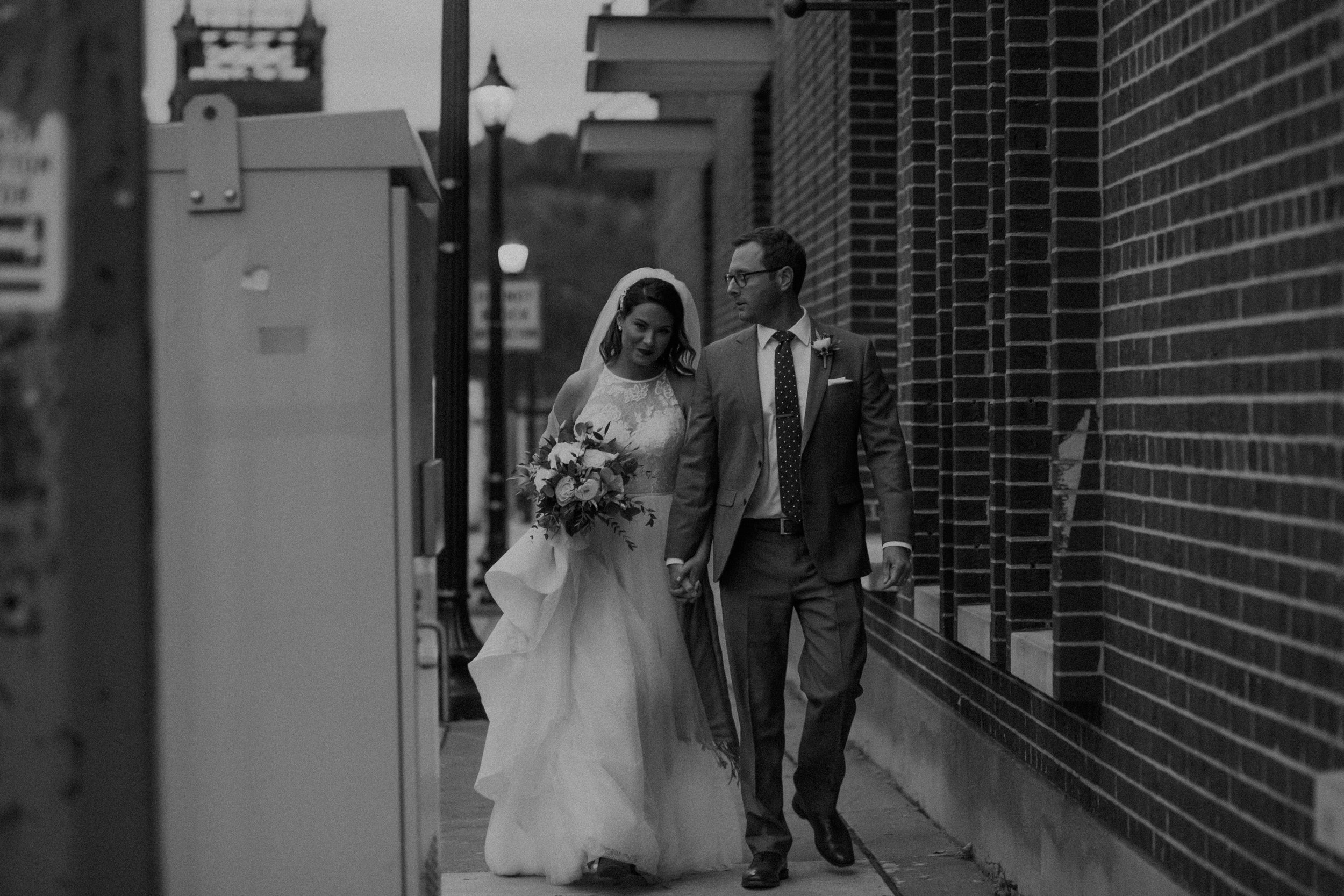 and bride and groom walk around the streets of Stillwater MN on their wedding day at sunset captured by Andrea Wagner Photography