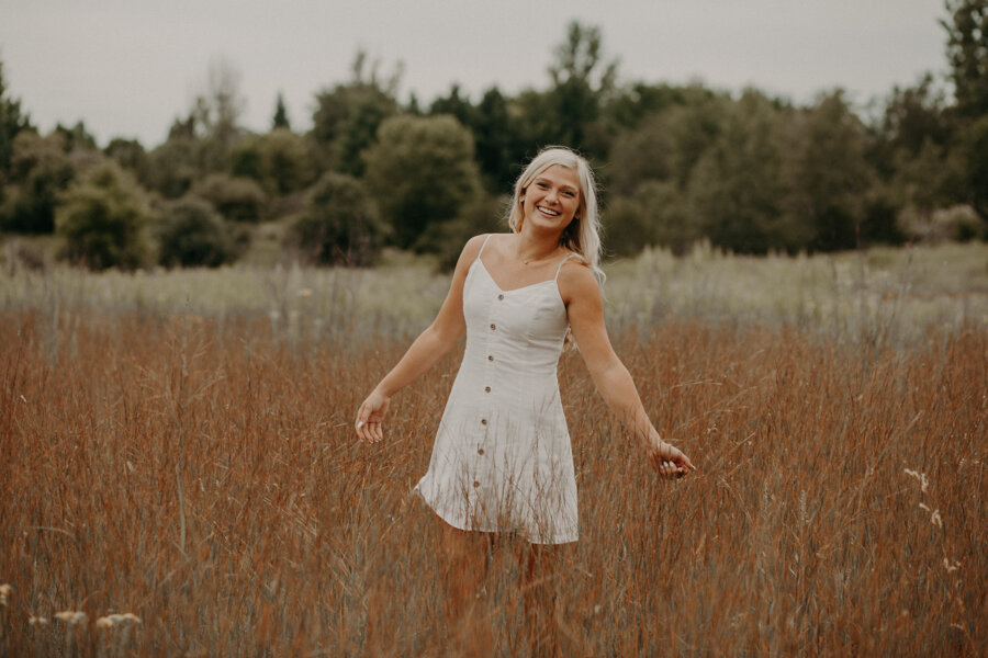  cumberland wisconsin high school senior frolicking in a field during her senior session with Andrea Wagner Photography 