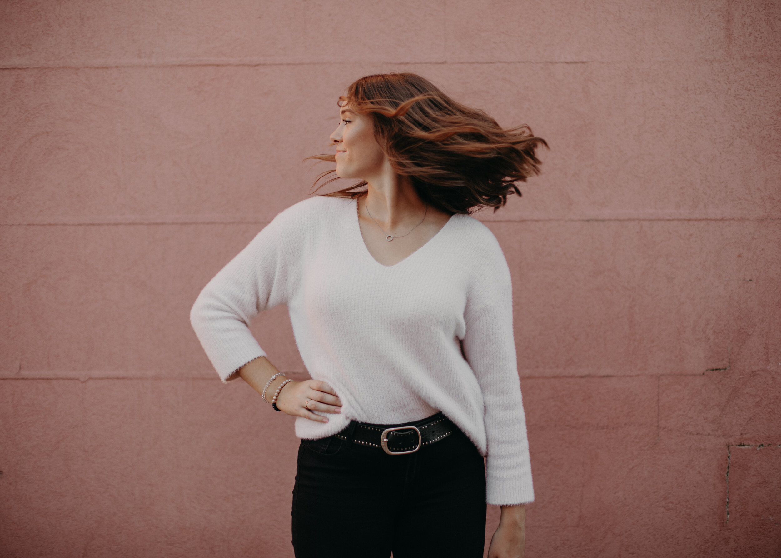  Pepperfest queen flips her hair in downtown Hudson against classic pink wall 