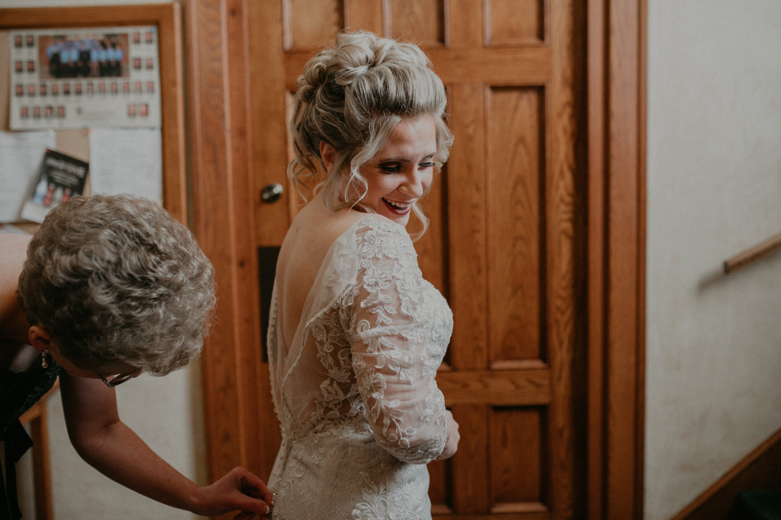  Andrea Wanger Photography cozy winter Wisconsin wedding. Perfect Wisconsin wedding in February. Elegant winter wedding bride getting into wedding dress. 