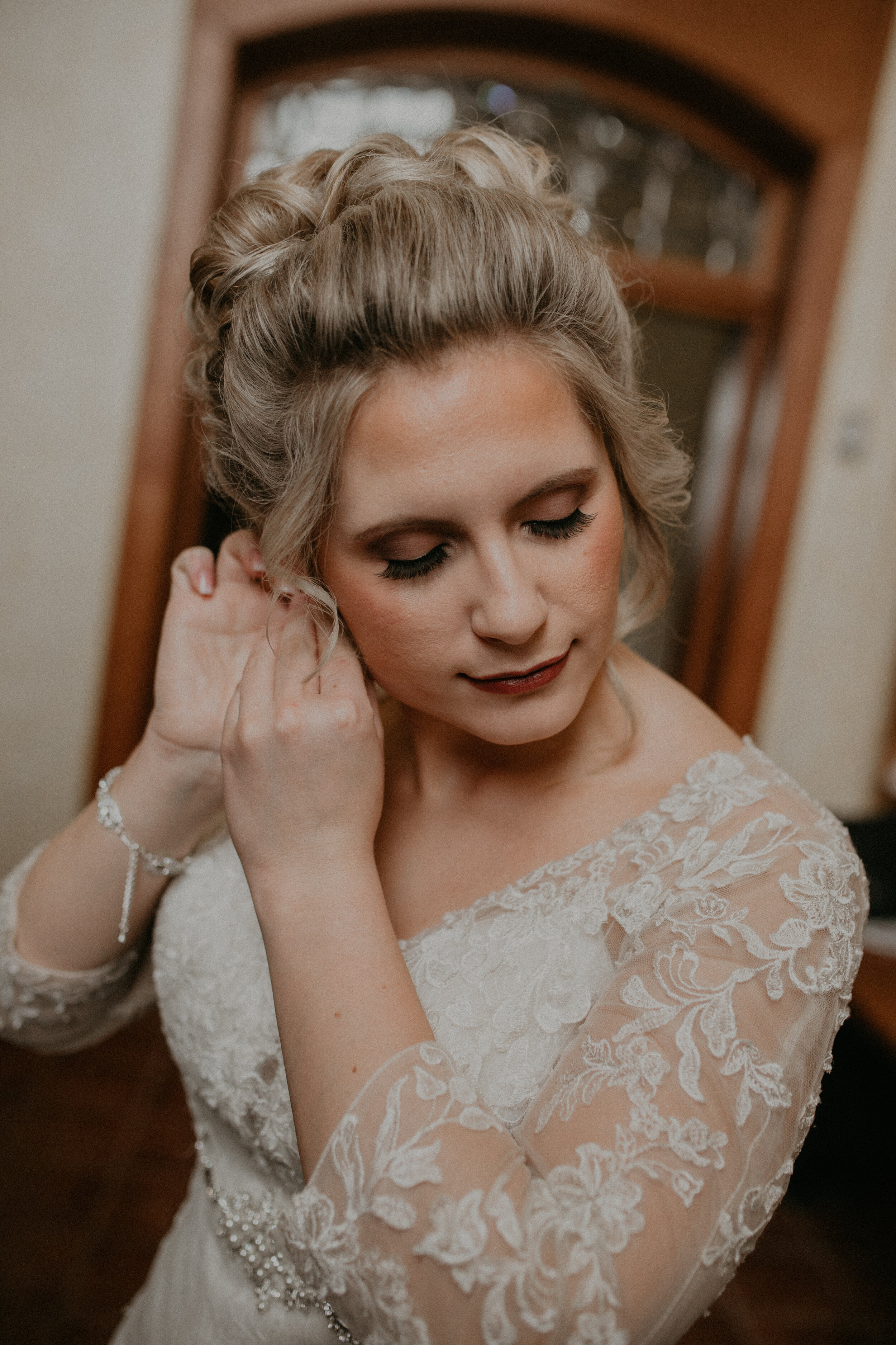  Andrea Wanger Photography cozy winter Wisconsin wedding. Perfect Wisconsin wedding in February. Elegant winter wedding bride putting on wedding accessories. 