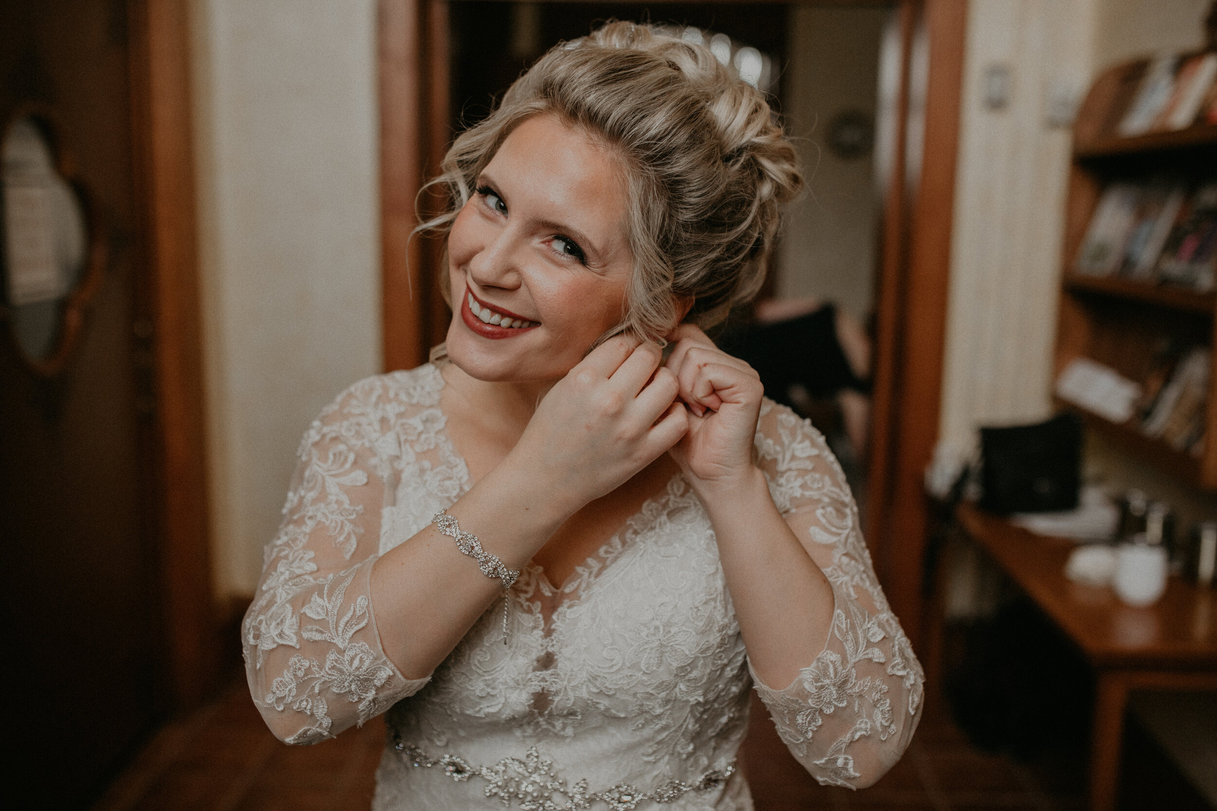  Andrea Wanger Photography cozy winter Wisconsin wedding. Perfect Wisconsin wedding in February. Elegant winter wedding bride putting on wedding accessories. 