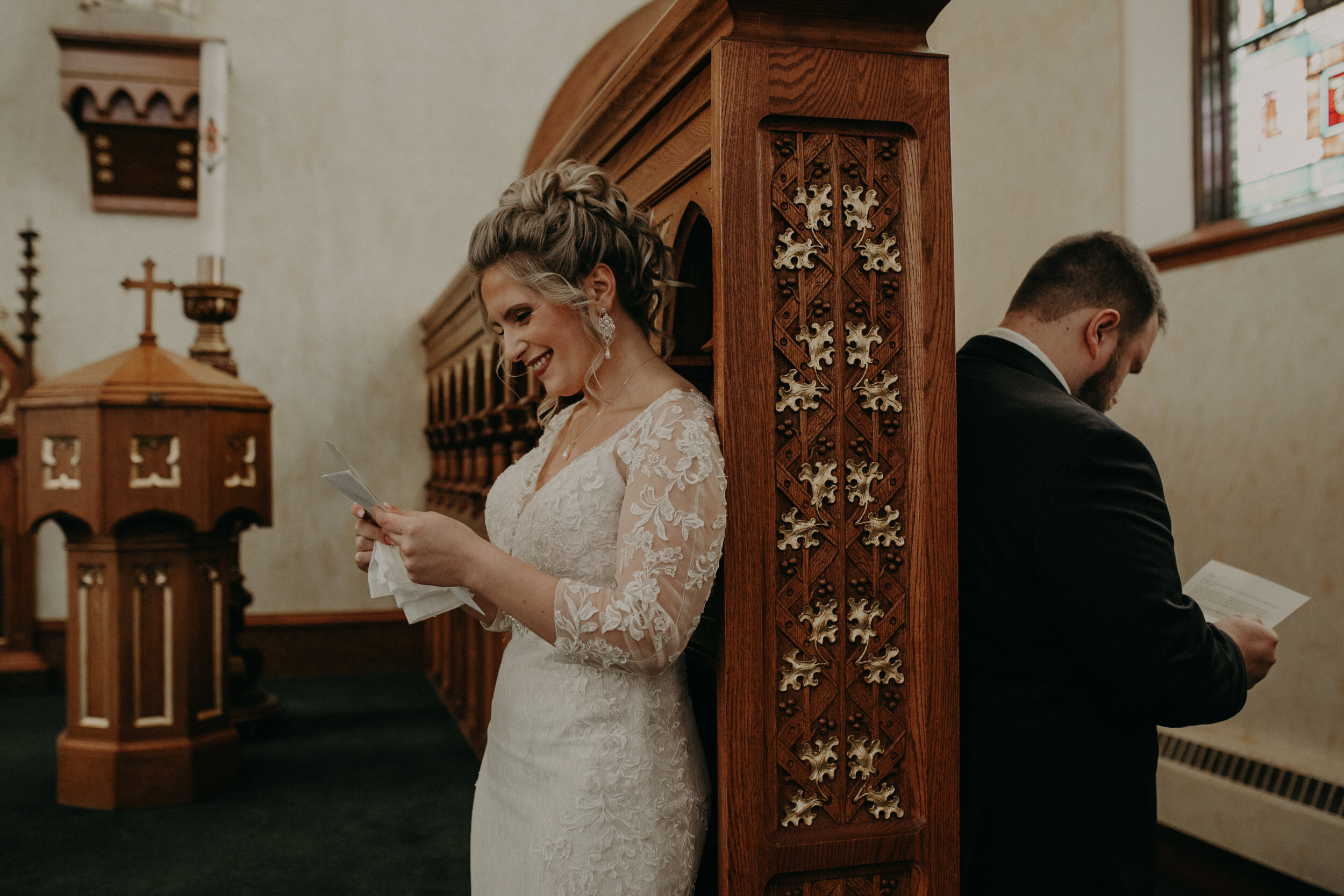 Andrea Wanger Photography cozy winter Wisconsin wedding. Perfect Wisconsin wedding in February. Elegant winter wedding bride and groom emotional reading letters in chuch. 