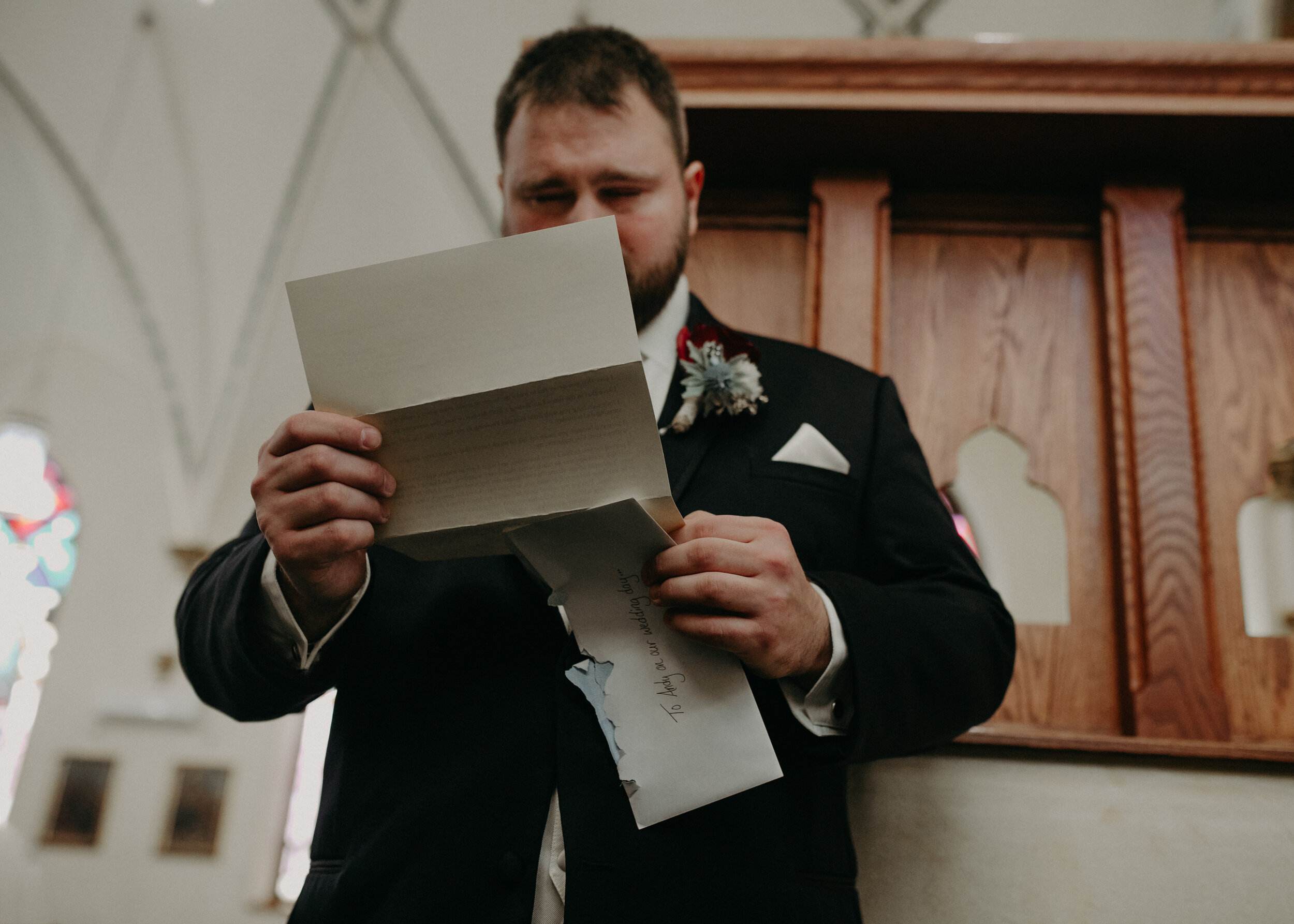  Andrea Wanger Photography cozy winter Wisconsin wedding. Perfect Wisconsin wedding in February. Elegant winter wedding bride and groom emotional reading letters in chuch. 