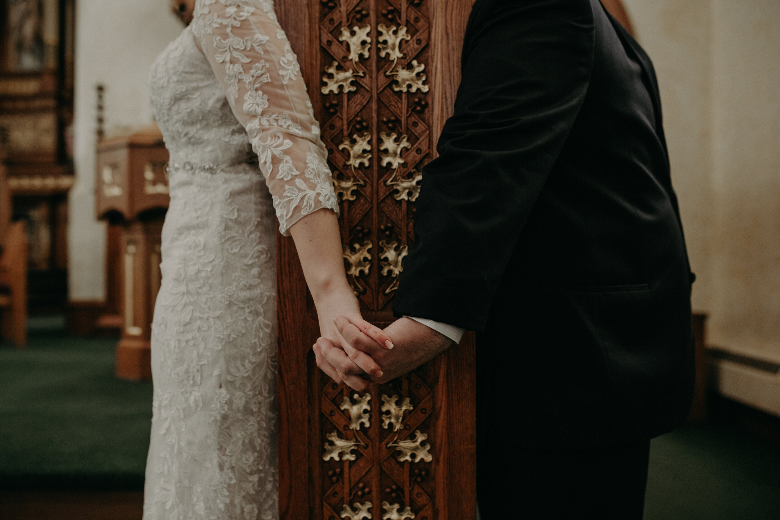  Andrea Wanger Photography cozy winter Wisconsin wedding. Perfect Wisconsin wedding in February. Elegant winter wedding bride and groom emotional reading letters in church holding hands. 