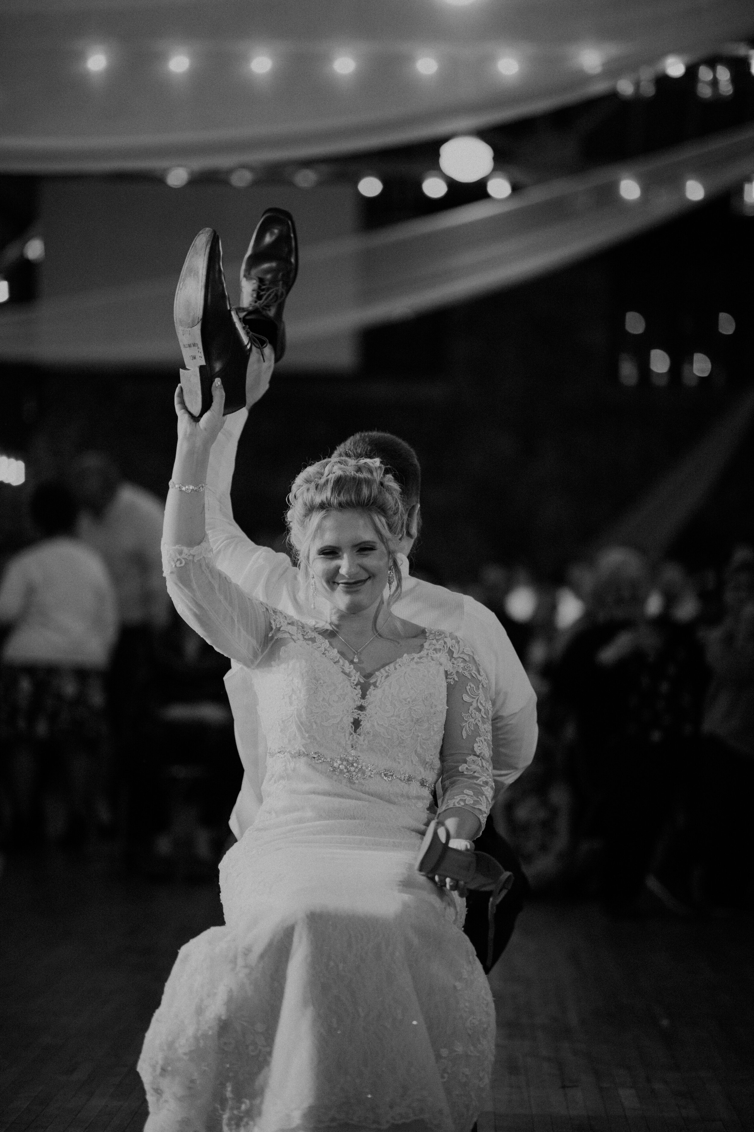  Andrea Wanger Photography cozy winter Wisconsin wedding. Perfect Wisconsin wedding in February. Elegant winter wedding. Reception bride and groom shoe game. Black and white. 