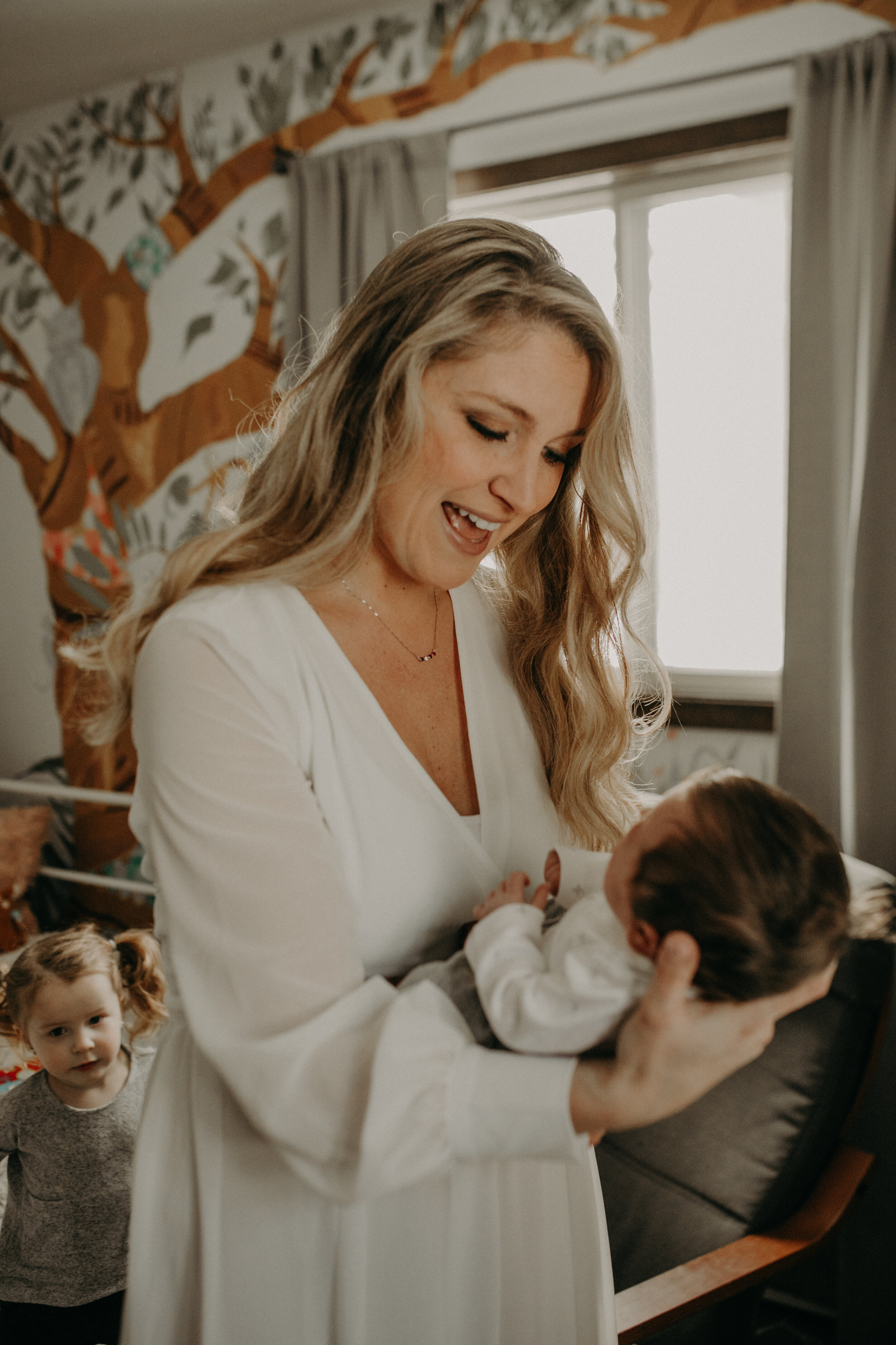  River Falls Family. River Falls Wisconsin. Mother cooking in the kitchen. Lifestyle Newborn Photo session. Wisconsin Newborn Photographer. Wisconsin Lifestyle Newborn Photographer. Lifestyle Newborn In Home Session. Beautiful mom in white making cho
