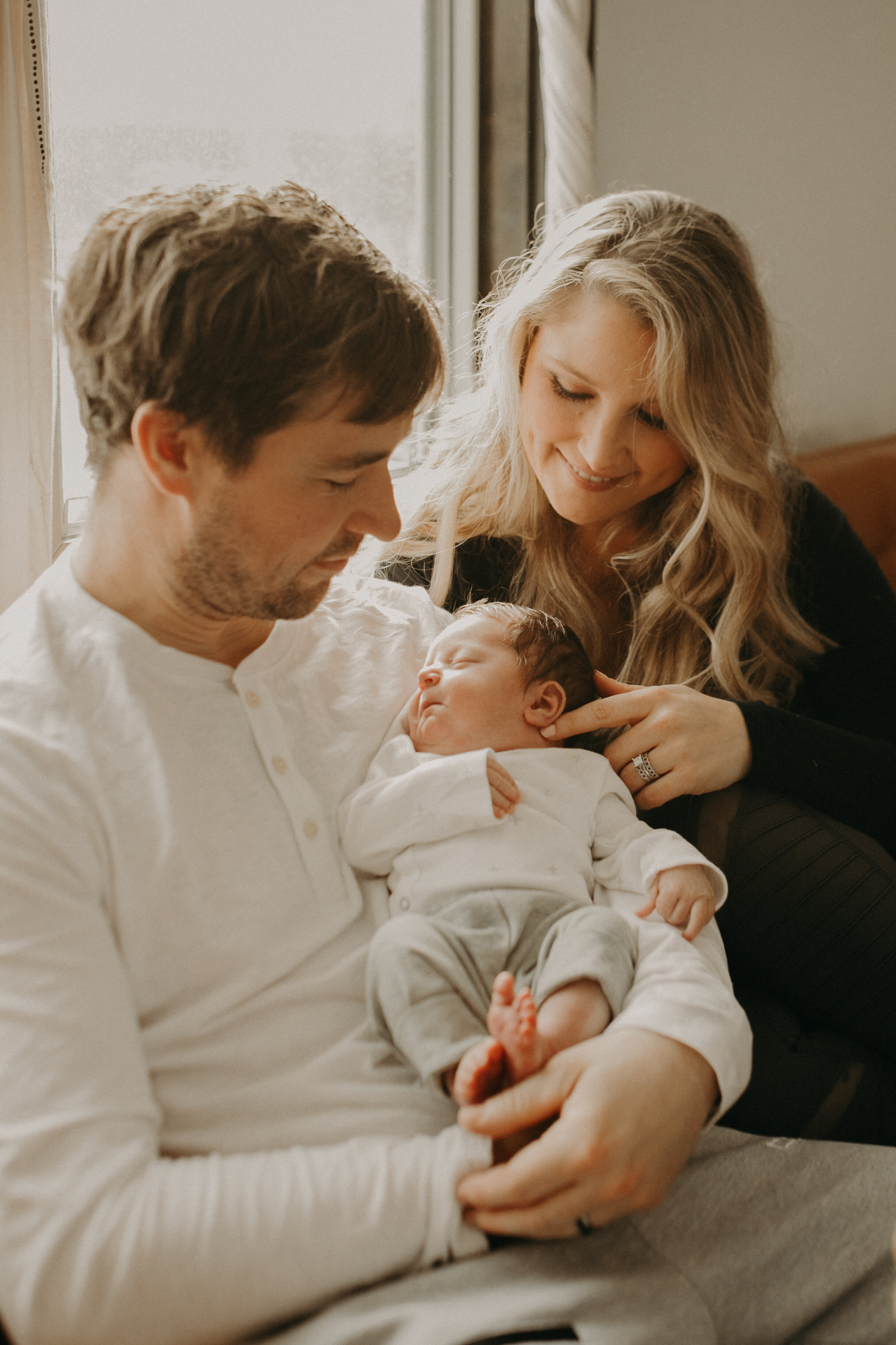  River Falls Family. River Falls Wisconsin. Mother cooking in the kitchen. Lifestyle Newborn Photo session. Wisconsin Newborn Photographer. Wisconsin Lifestyle Newborn Photographer. Lifestyle Newborn In Home Session. Beautiful mom in white making cho