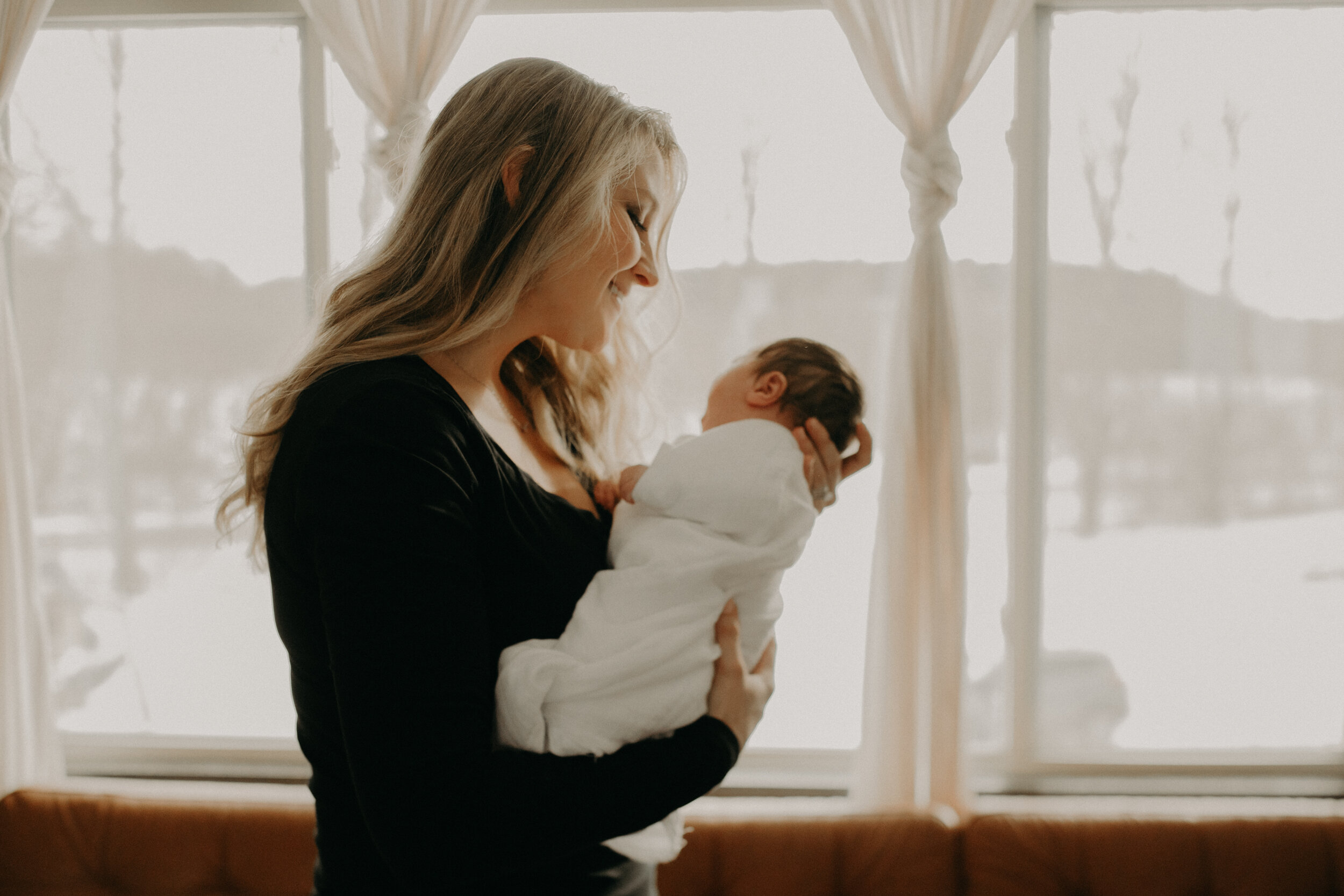  River Falls Family. River Falls Wisconsin. Mother cooking in the kitchen. Lifestyle Newborn Photo session. Wisconsin Newborn Photographer. Wisconsin Lifestyle Newborn Photographer. Lifestyle Newborn In Home Session. Beautiful mom in white making cho