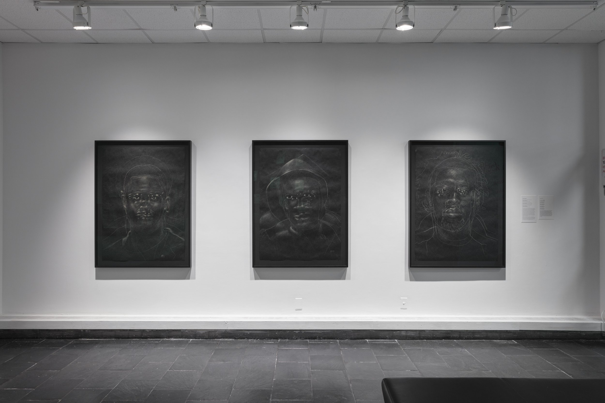  Installation view of  The Black Index  at Hunter College Art Galleries’ Leubsdorf Gallery, 2022. Photo: Stan Narten. Works by Titus Kaphar, left to right:  The Jerome Project (Asphalt and Chalk) XV , 2015. Chalk on asphalt paper, 49 x 36 inches. The