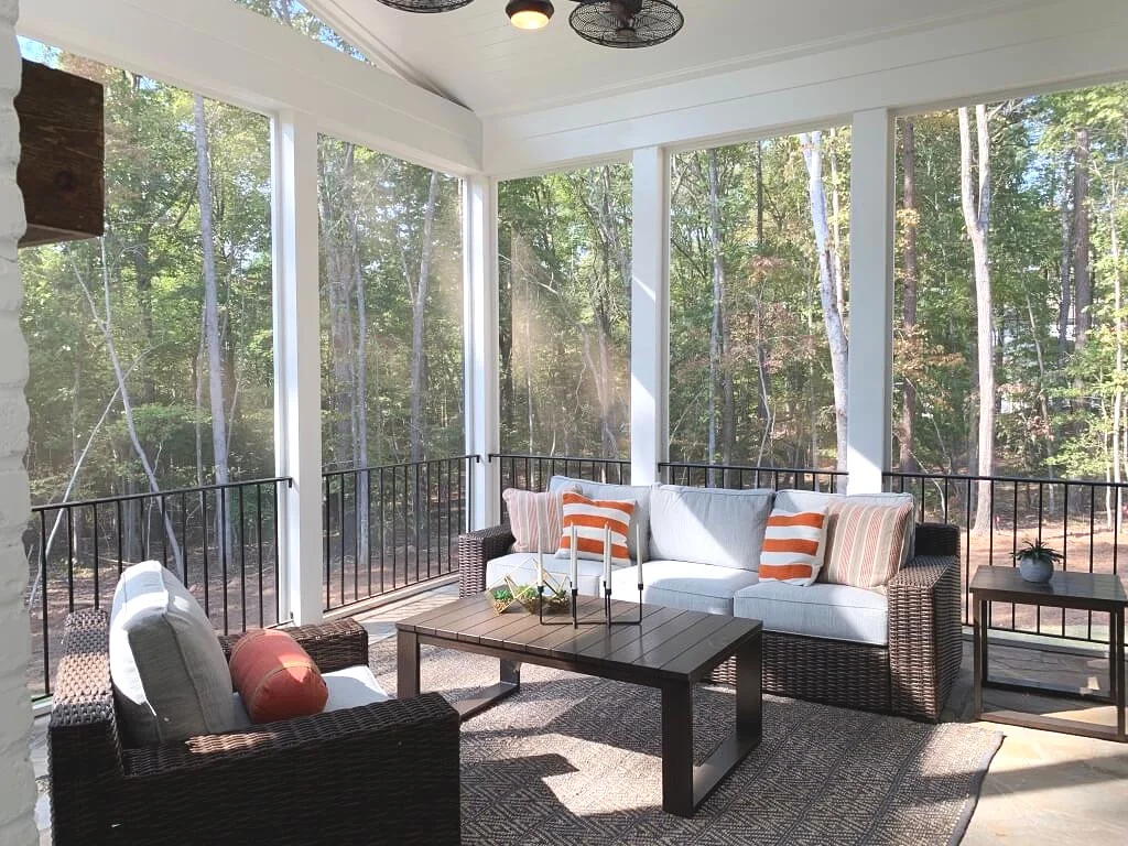 Screened in porch furniture and iron railing.