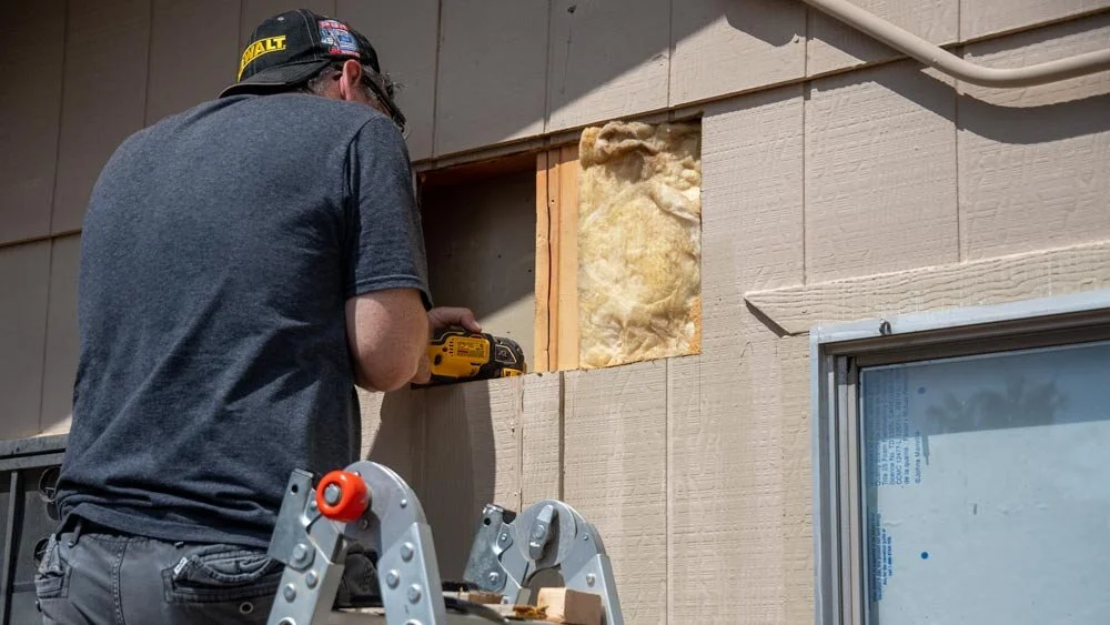 Cutting below the edge of the siding to fit new framing.