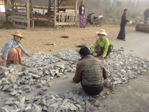 Road-making in Myanmar – Village women sorting rocks prior to the laying of the road