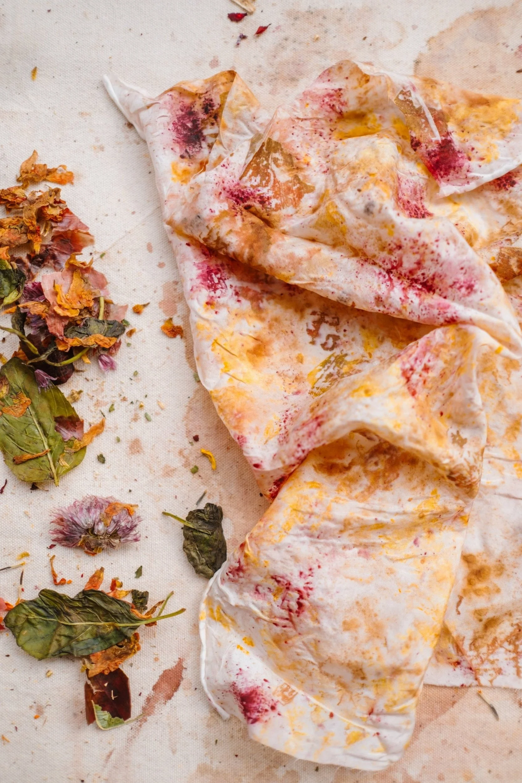 Eco-printed fabric with colorful stains and dried flowers