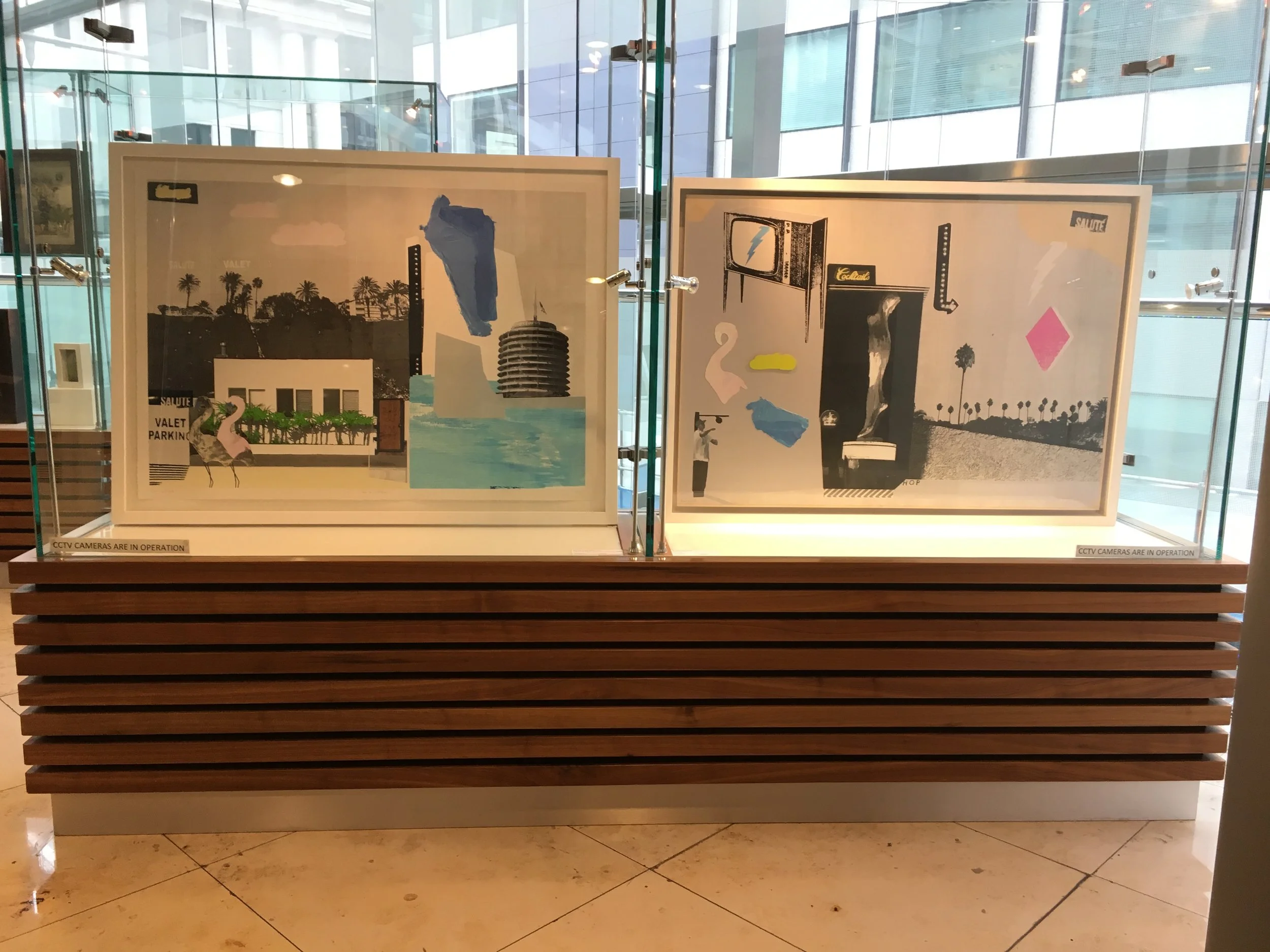 Second display case at the top of escalator featuring Bonnie and Clyde original collage Cocktail Hour and limited edition print From the City to the Sea