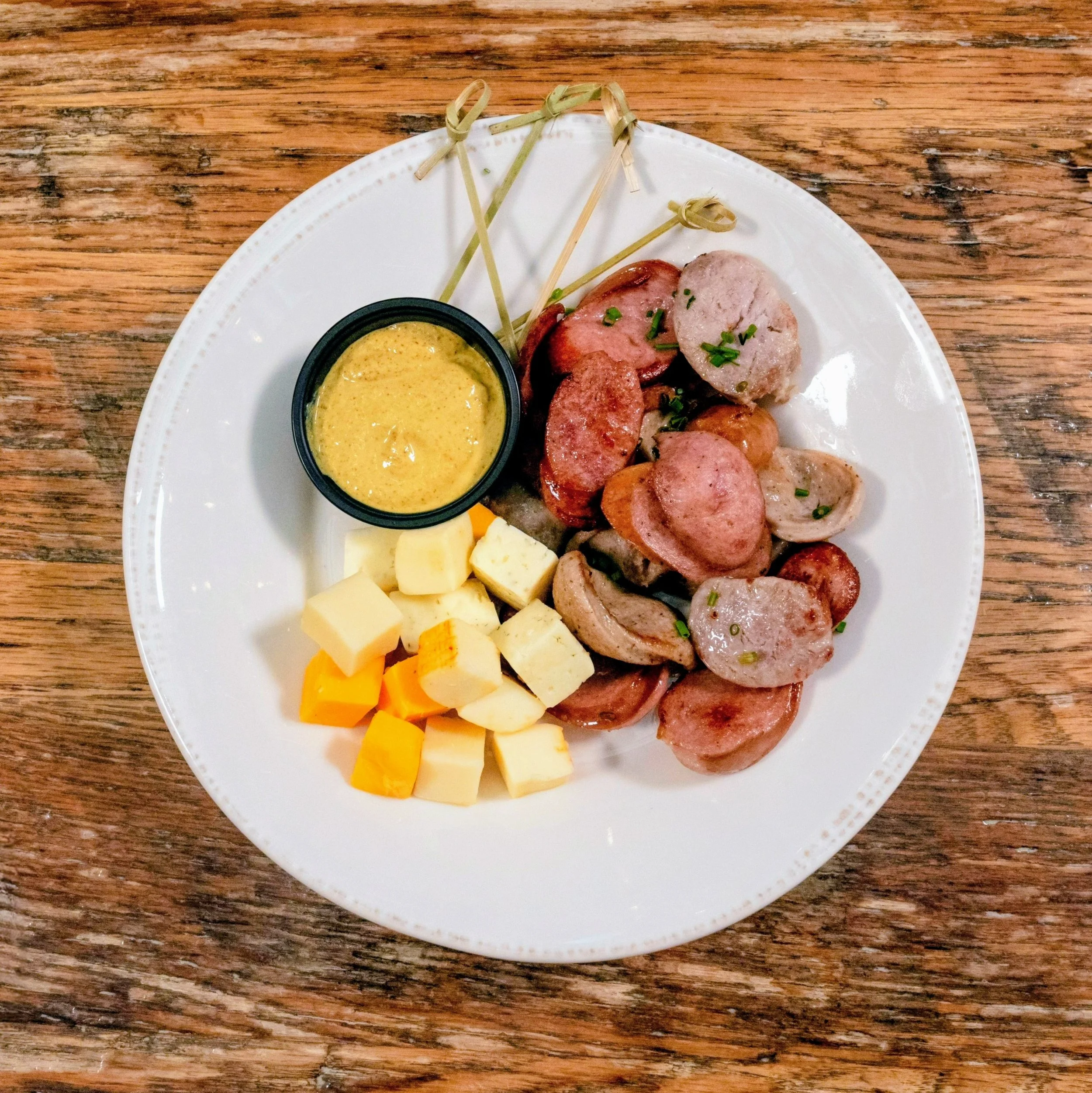 Assorted wurst with assorted cheeses and mustard.