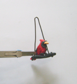 step 11 - Bend the loops forward to face each other. Insert the perch ends into the loops. Glue the bird’s claws to the perch and allow it to set.