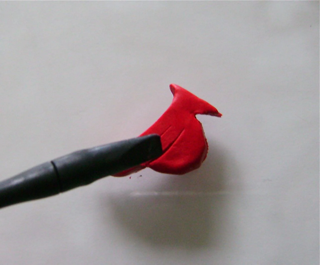 step 7 - Use the sharp edge of the sculpting tool to create lines representing the wing.