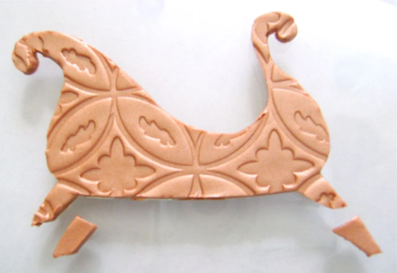 step 4 - Cut out two additional sleigh legs from the extra copper clay. Set these pieces aside.
