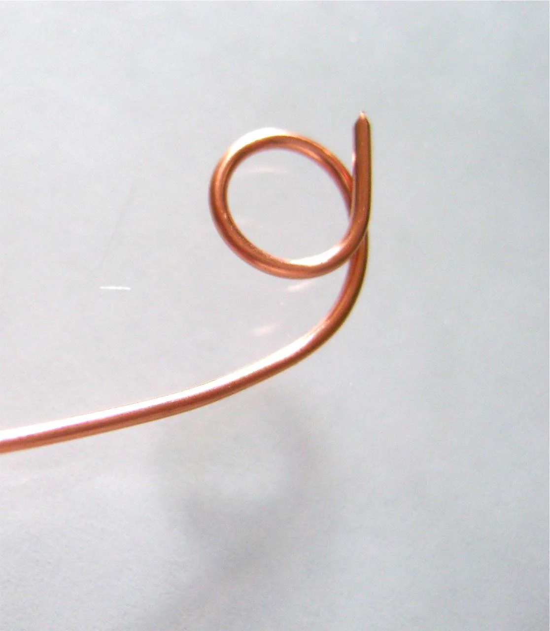 step 6 - Create the sleigh runner with a piece of 18 gauge copper wire about 6” long. Wrap the ends around a round object about the size of a marker.