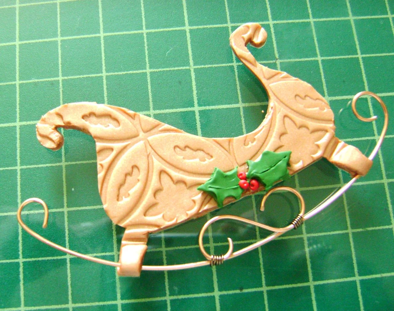 step 10 - Place the runner on the legs of the sleigh. Press lightly into the clay. Cover with the extra leg pieces and press together.